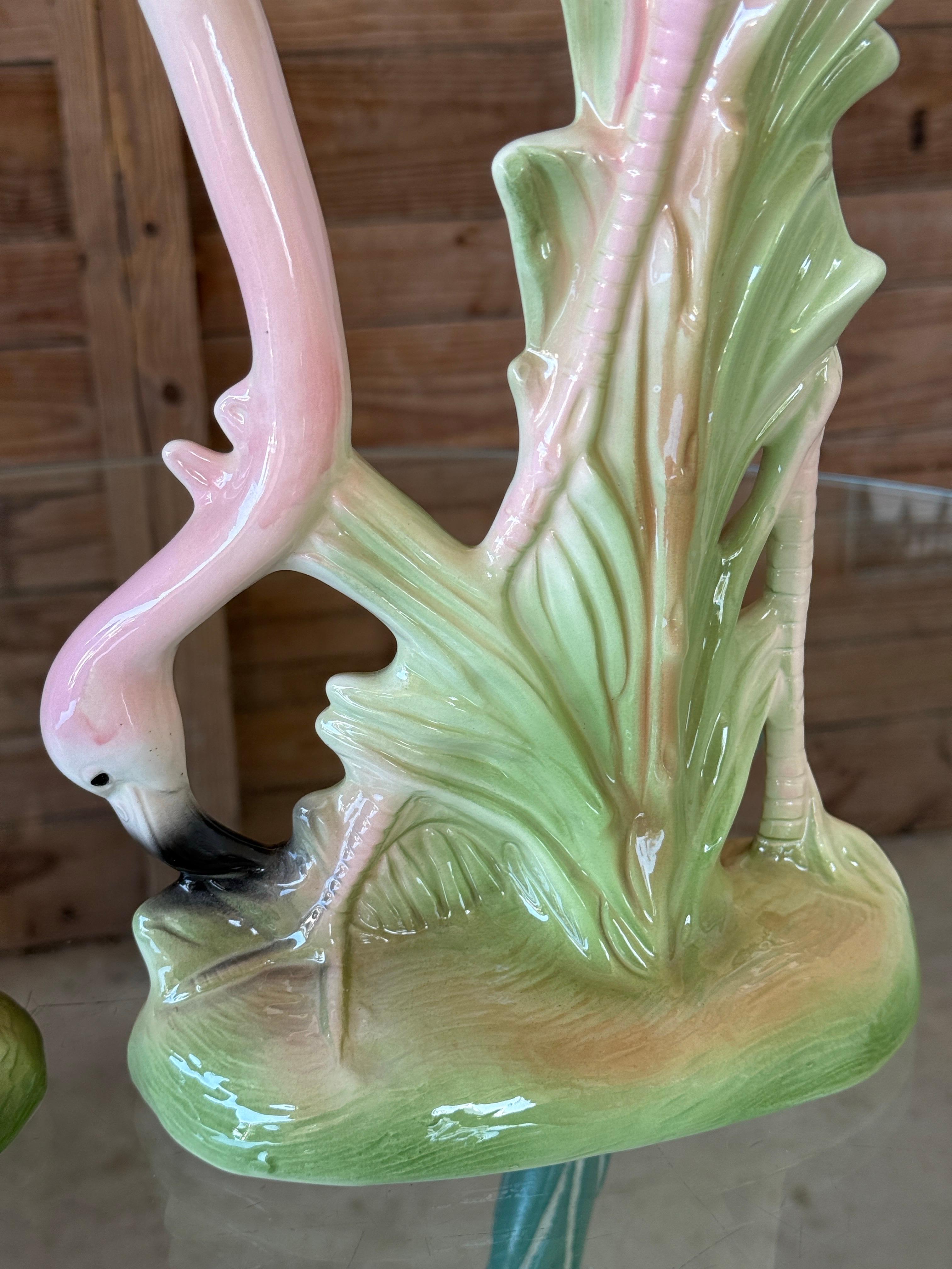 Magnifique paire de grandes figurines de flamants roses en céramique vintage de Great Plains, présentant des corps de plumes roses et noires magnifiquement détaillés avec des bases de feuillage vert vibrant.
Chaque pièce présente une pose unique,