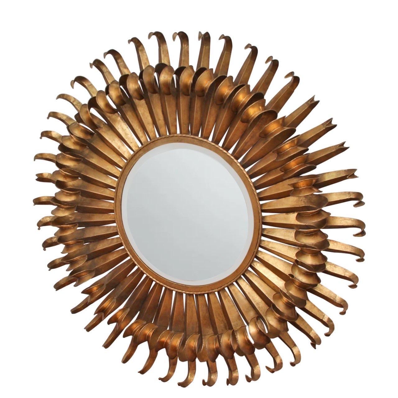 Very large starburst mirror crafted of iron.  

France, circa 1950.

Features alternating rays with original gold leaf gilding and original aged patina.

Dimensions: 50” W x 6” D / Mirror: 20” W