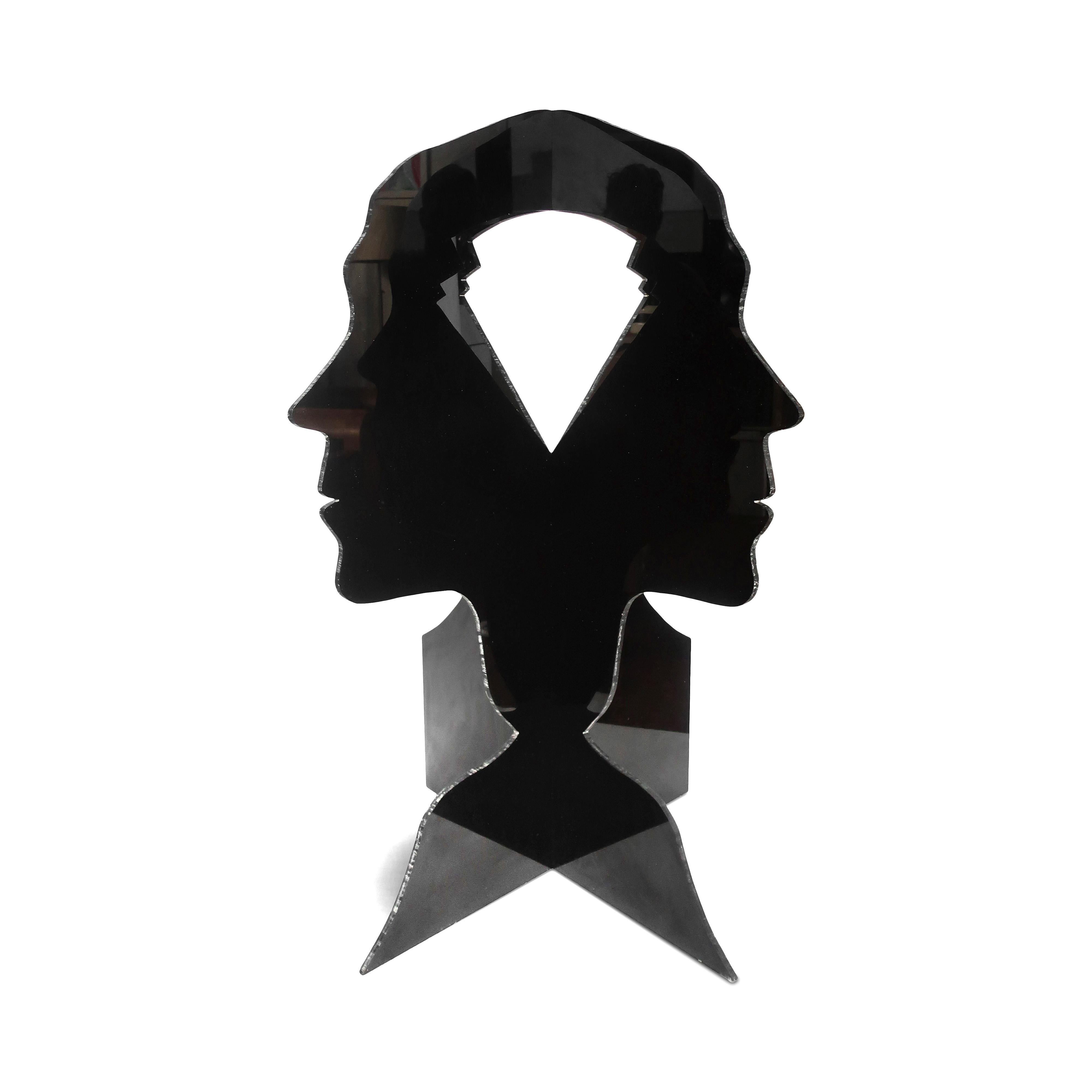 An amazing large three dimensional sculpture of the silhouette of a person’s head, neck, and shoulder constructed from two pieces of black lucite. The two pieces each have a cut out shape where the brain would be which creates yet another three
