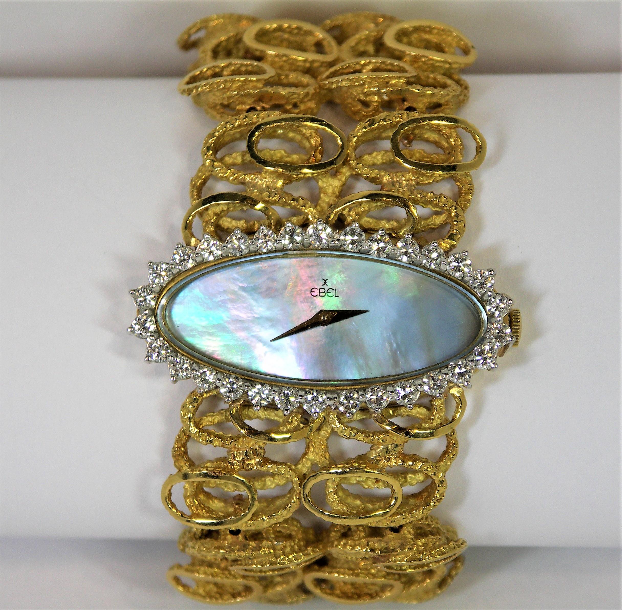 This vintage, 18K Yellow Gold ladies Ebel Watch has a huge, oval shaped
Mother of Pearl dial surrounded by 30 round brilliant cut diamonds weighing an approximate total of 3.0Ct of G Color and VS2 Clarity. The
watch including the diamond bezel