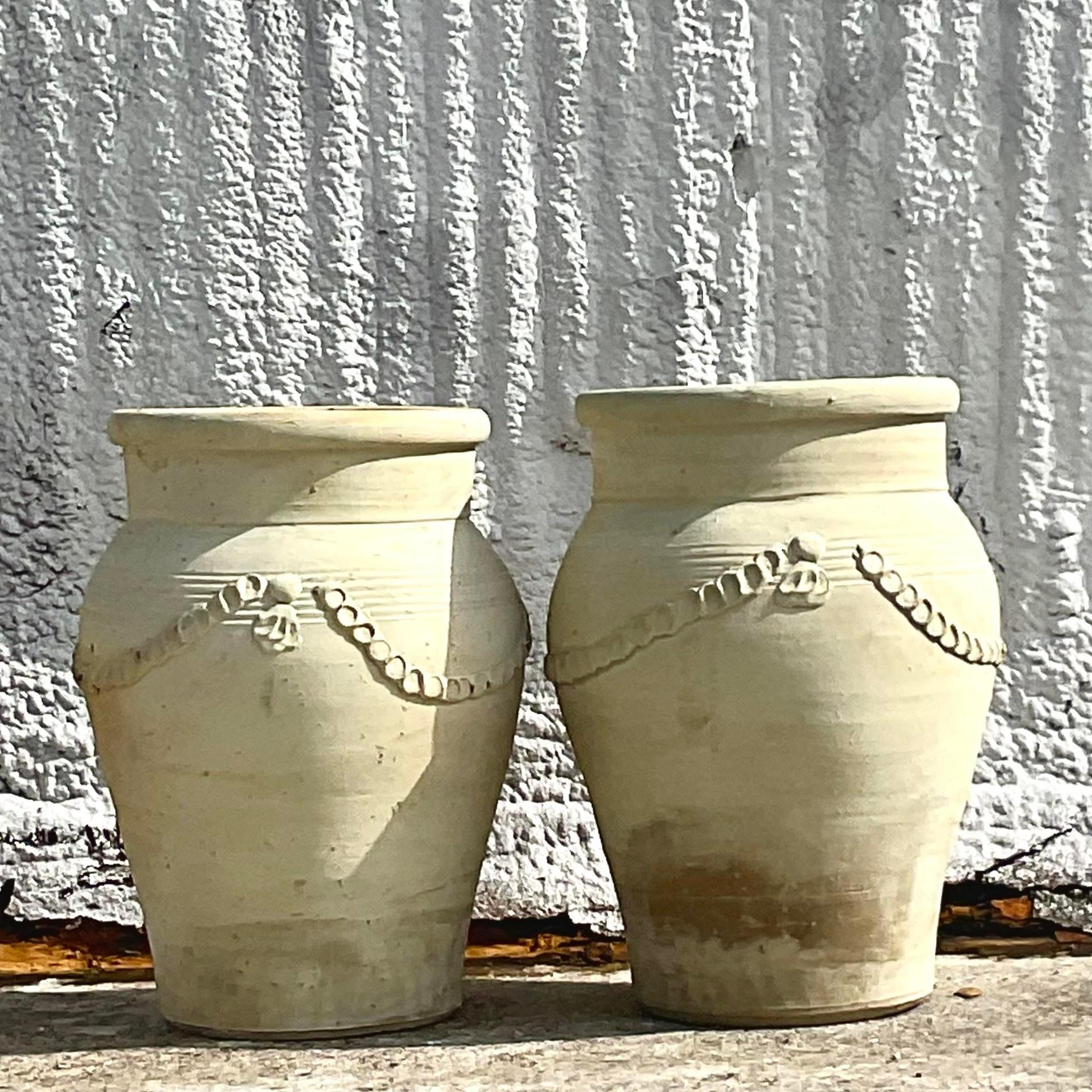 A pair of gorgeous vintage terracotta planters. Painted in a lovely cream color with stunning details on the surface. Lots of great patina from time. Acquired at a Palm Beach estate.