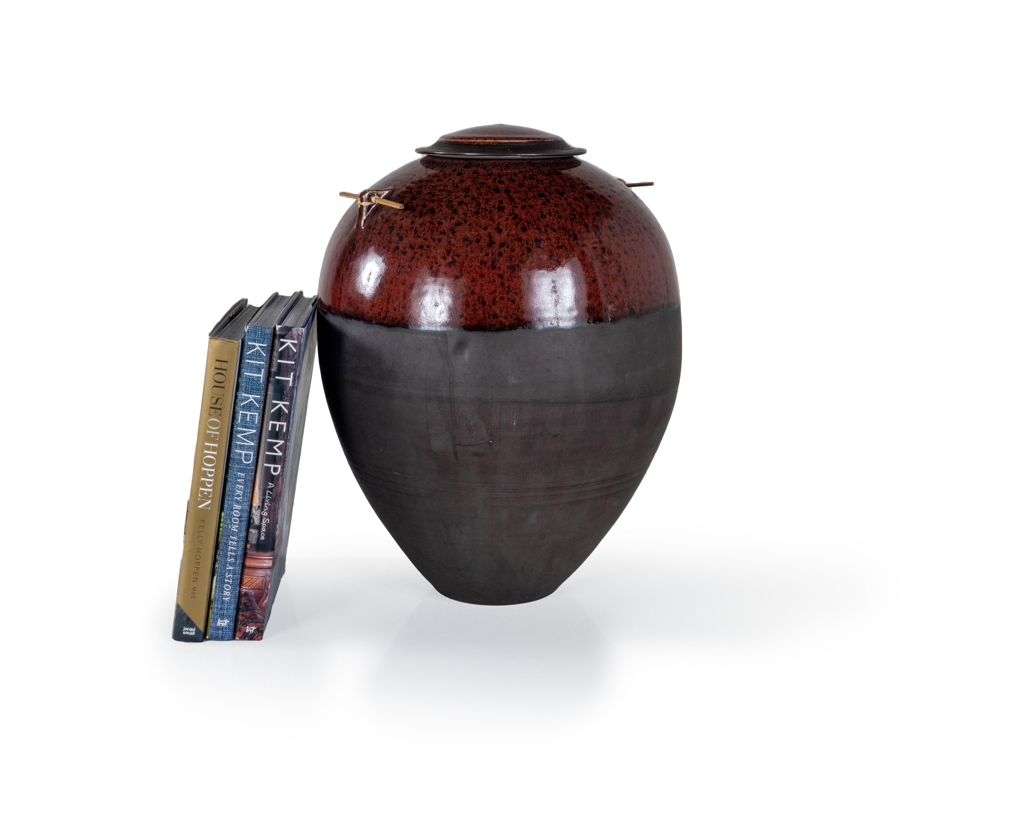 The Vintage Monumental Stephen Merritt Vase is a beautiful and unique form of pottery that was created by the artist Stephen Merritt in the mid-century modern era. This ceramic jar features split bamboo handles and a ginger jar body with removable