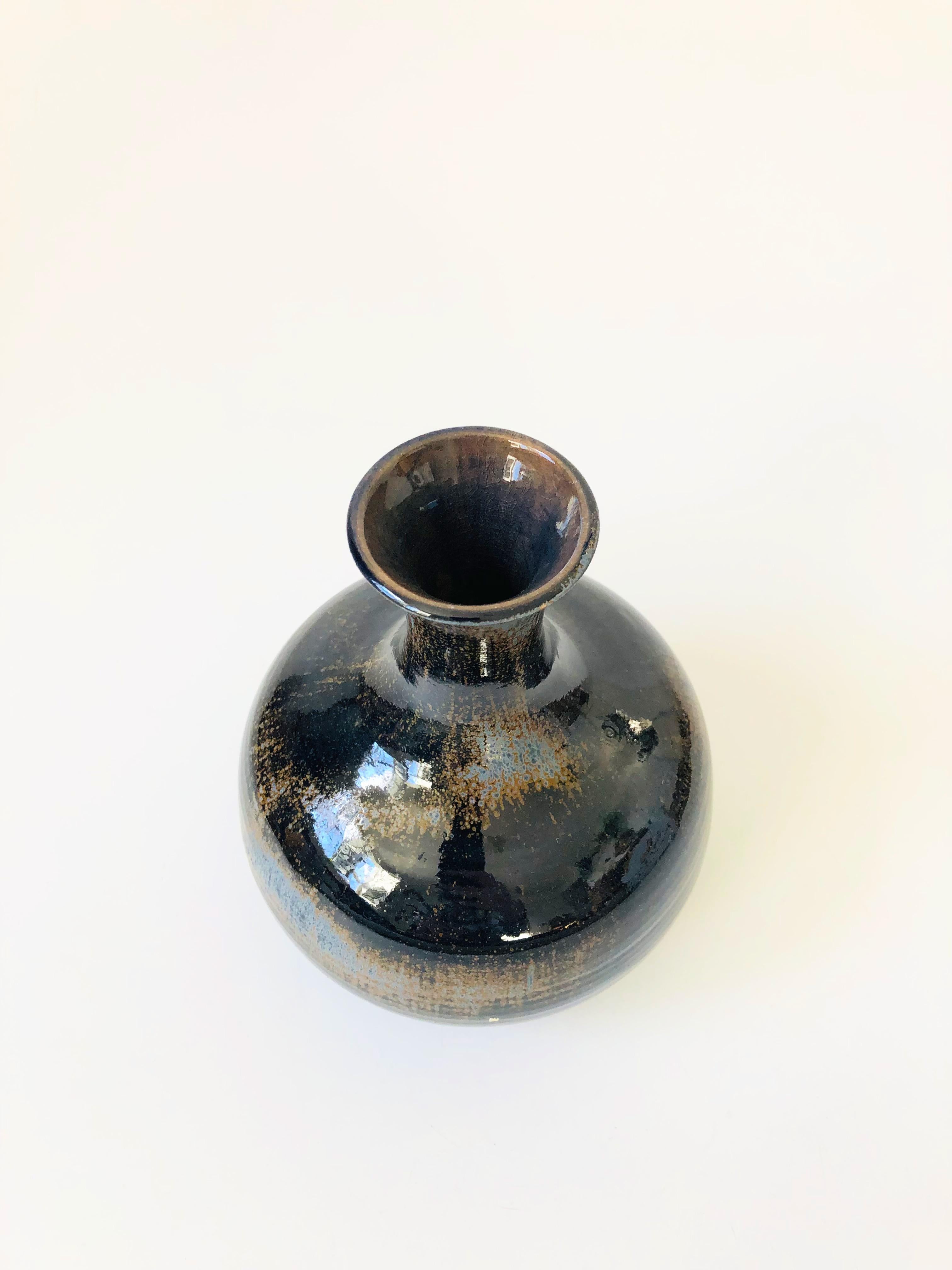 A vintage pottery vase. Nice classic shape with a moody dark blue glaze that fades from dark blue to light blue to brown. Felted base.
 
