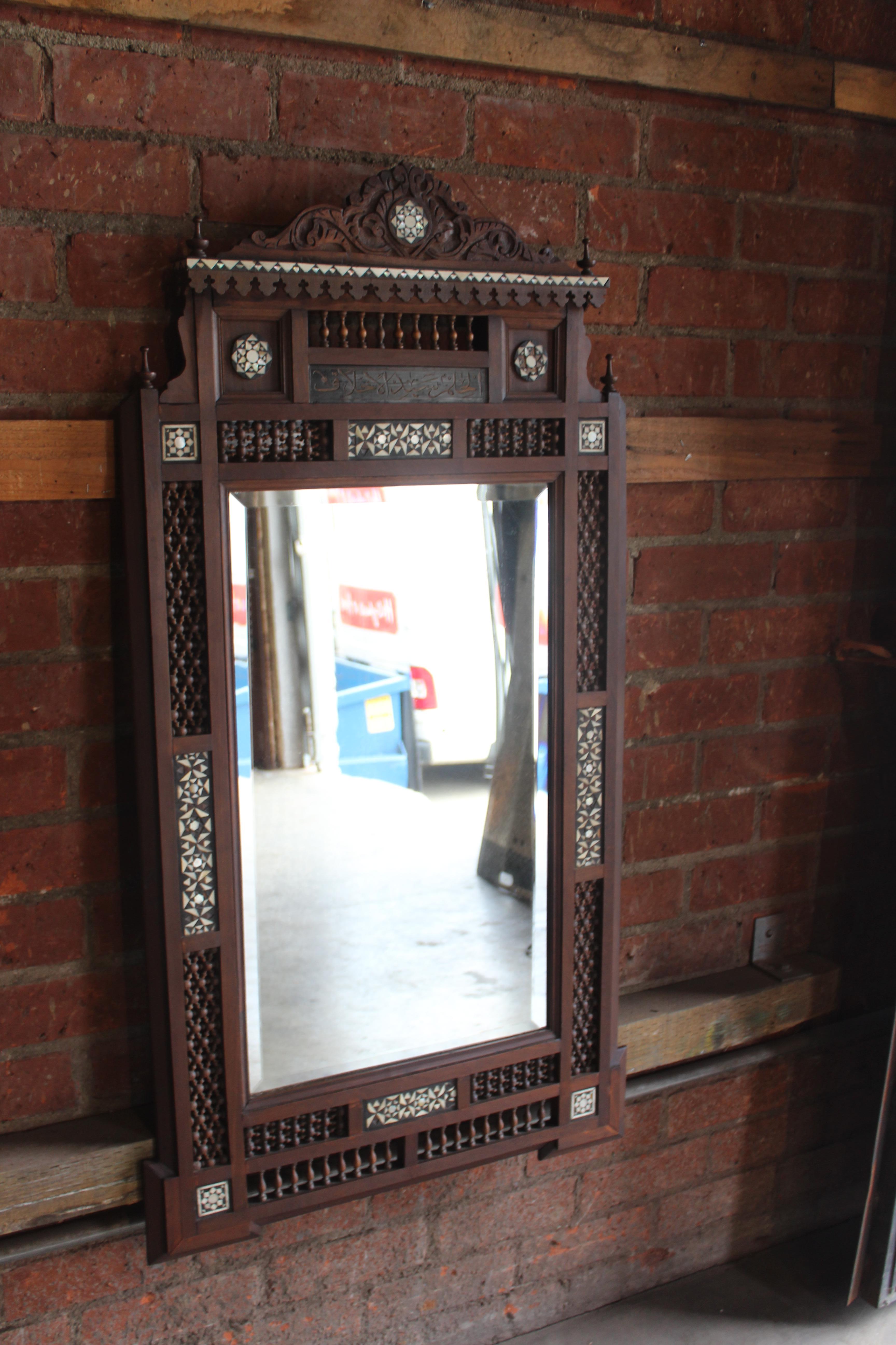 An antique Moorish style inlaid and carved wood wall mirror.