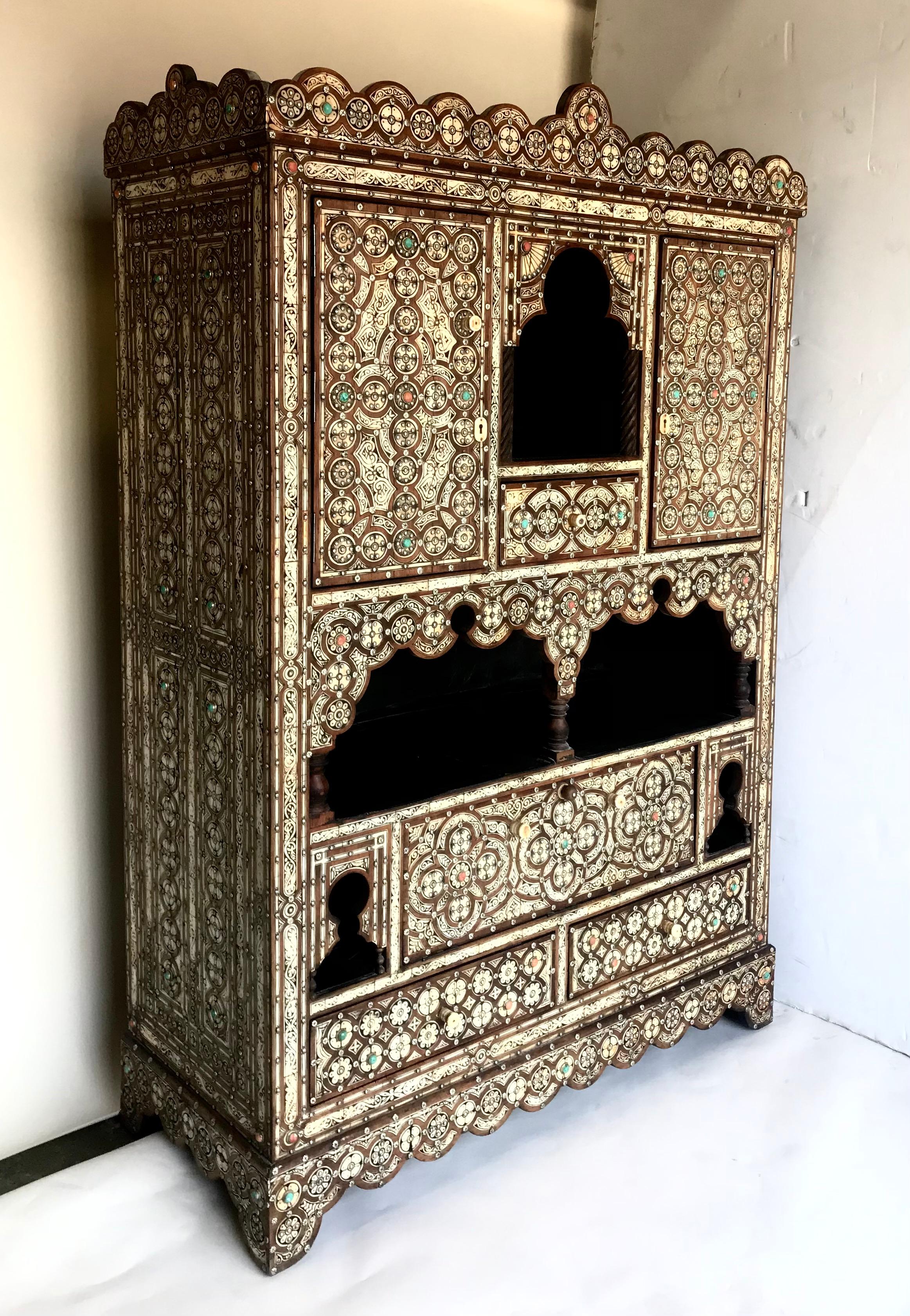 Vintage Moroccan inlay cabinet with Moorish arches and details. This inlay artwork is constructed with light color bone, darker wood and silver studs, making intricate patterns. It is a striking piece. Interior is lined in black leather.
There are