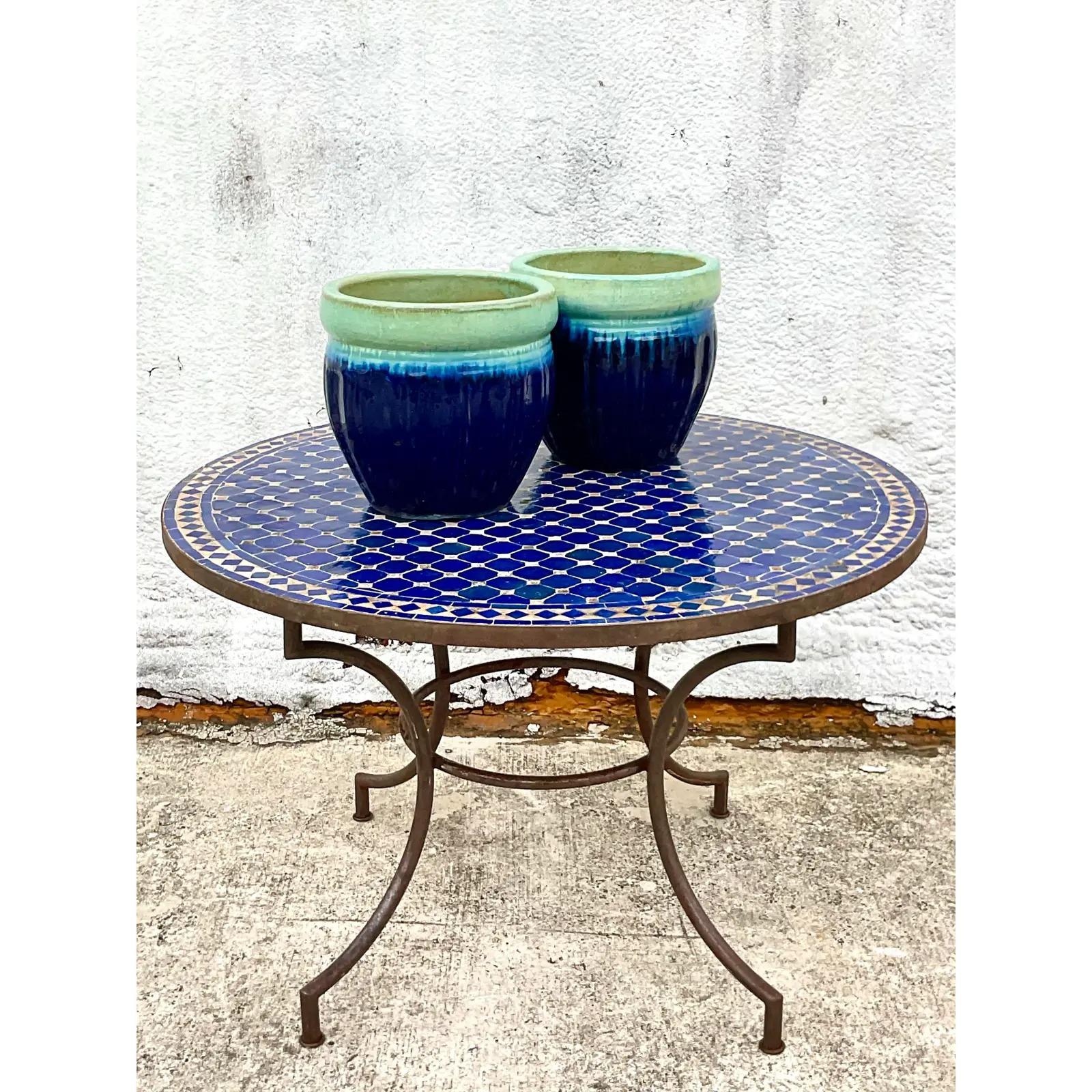 A fantastic vintage Moorish dining table. Beautiful Moroccan tile in a brilliant blue color. Rests on a wrought iron pedestal base. Acquired from a Palm Beach estate.
