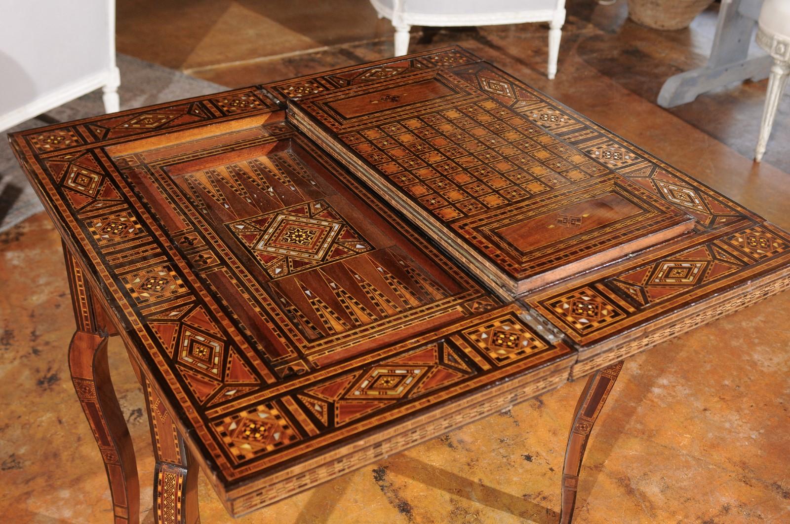 Tavolo da gioco marocchino in stile moresco della fine del XX secolo, con intarsi molto complessi e piano pieghevole. Nato in Marocco negli ultimi anni del XX secolo, questo squisito tavolo da gioco è caratterizzato da un piano rettangolare che si