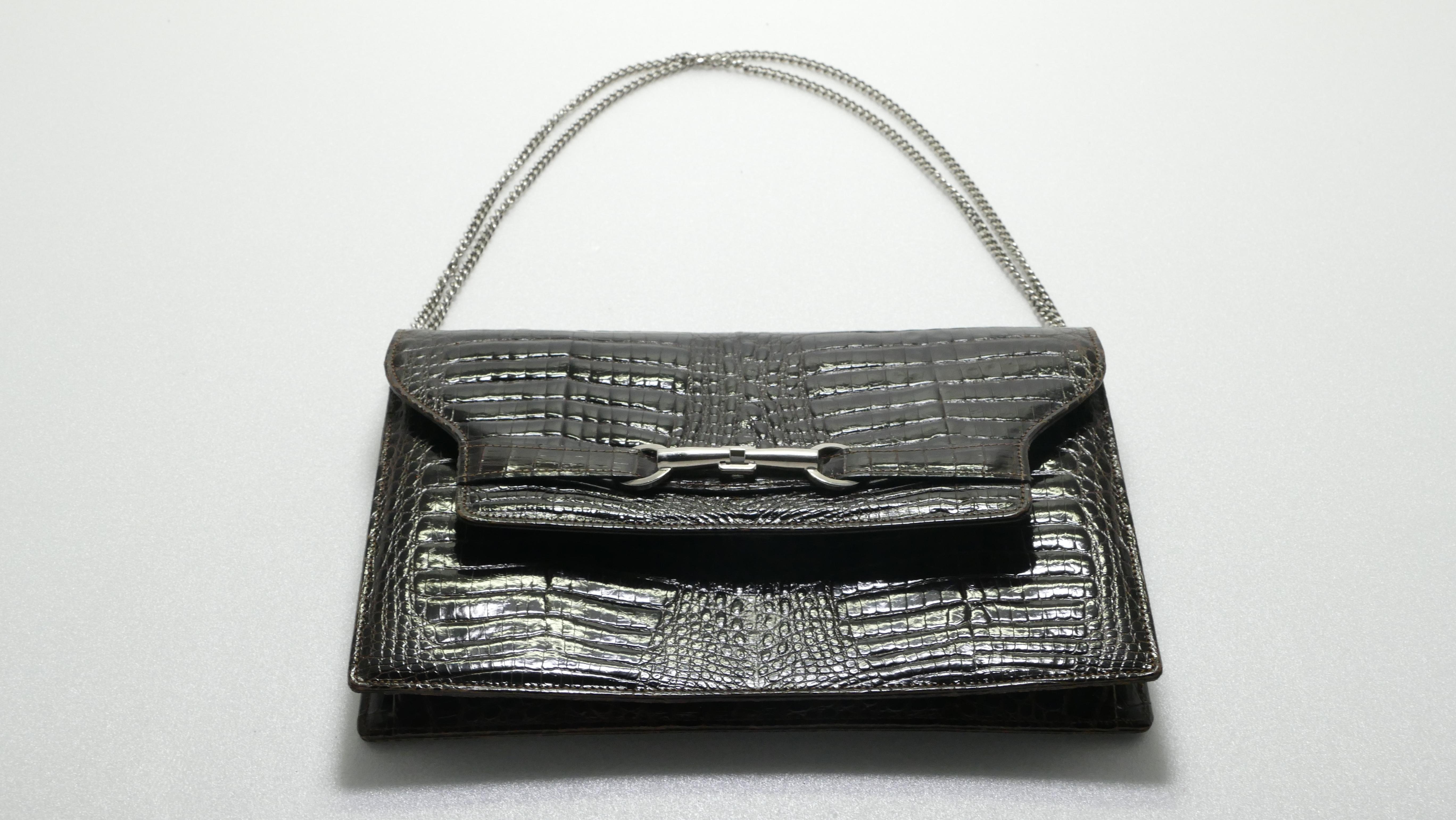 Ce magnifique sac à main Morabito Paris est réalisé en crocodile marron, avec une anse supérieure et des ferrures argentées. Sa fermeture magnétique à trou s'ouvre sur un intérieur en cuir d'Agneau marron foncé avec deux compartiments et une