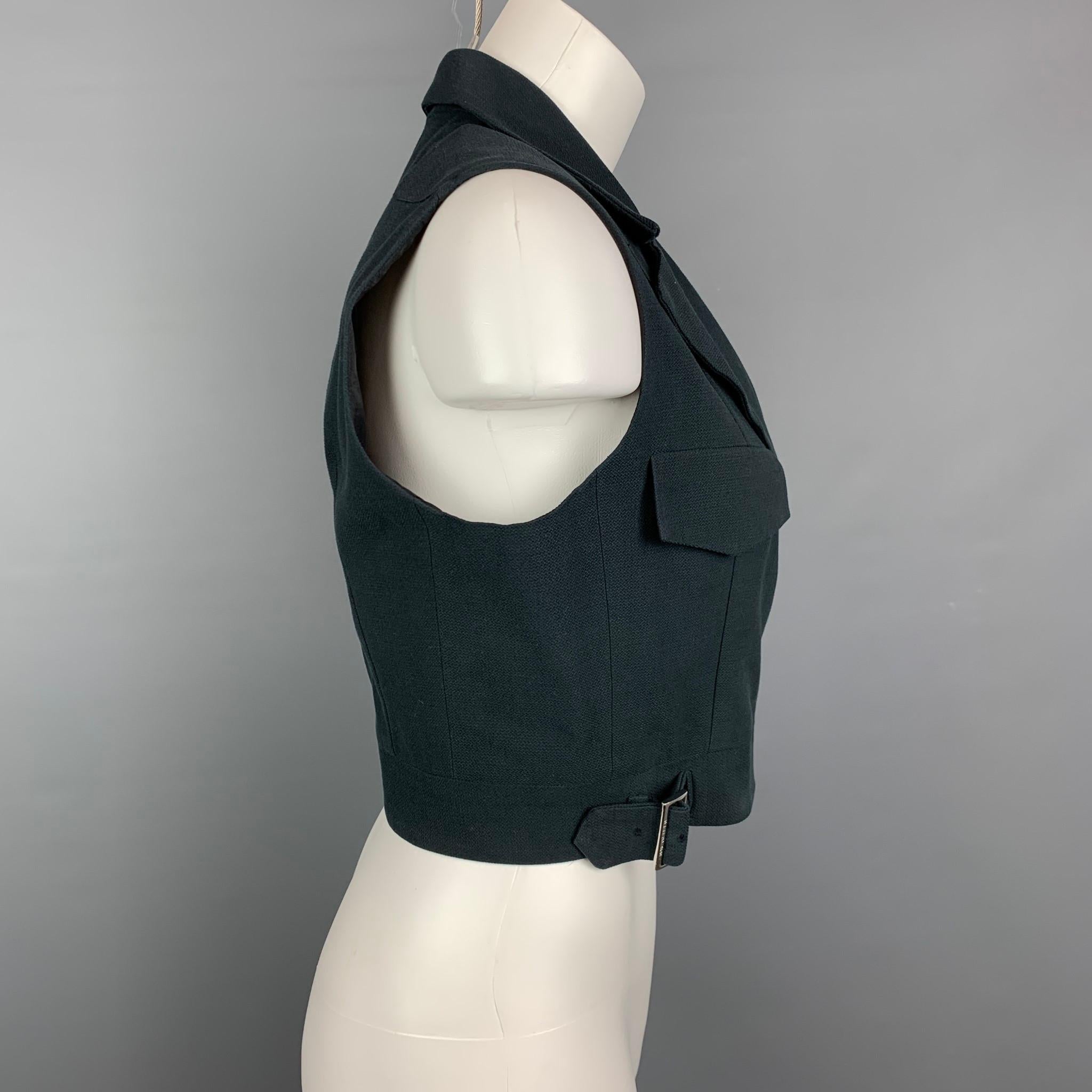 Vintage MORGANE LE FA vest comes in a black textured cotton with a full liner featuring a notch lapel, sleeveless, flap pockets, and a front double strap buckle closure. Made in USA. 

Very Good Pre-Owned Condition.
Marked: