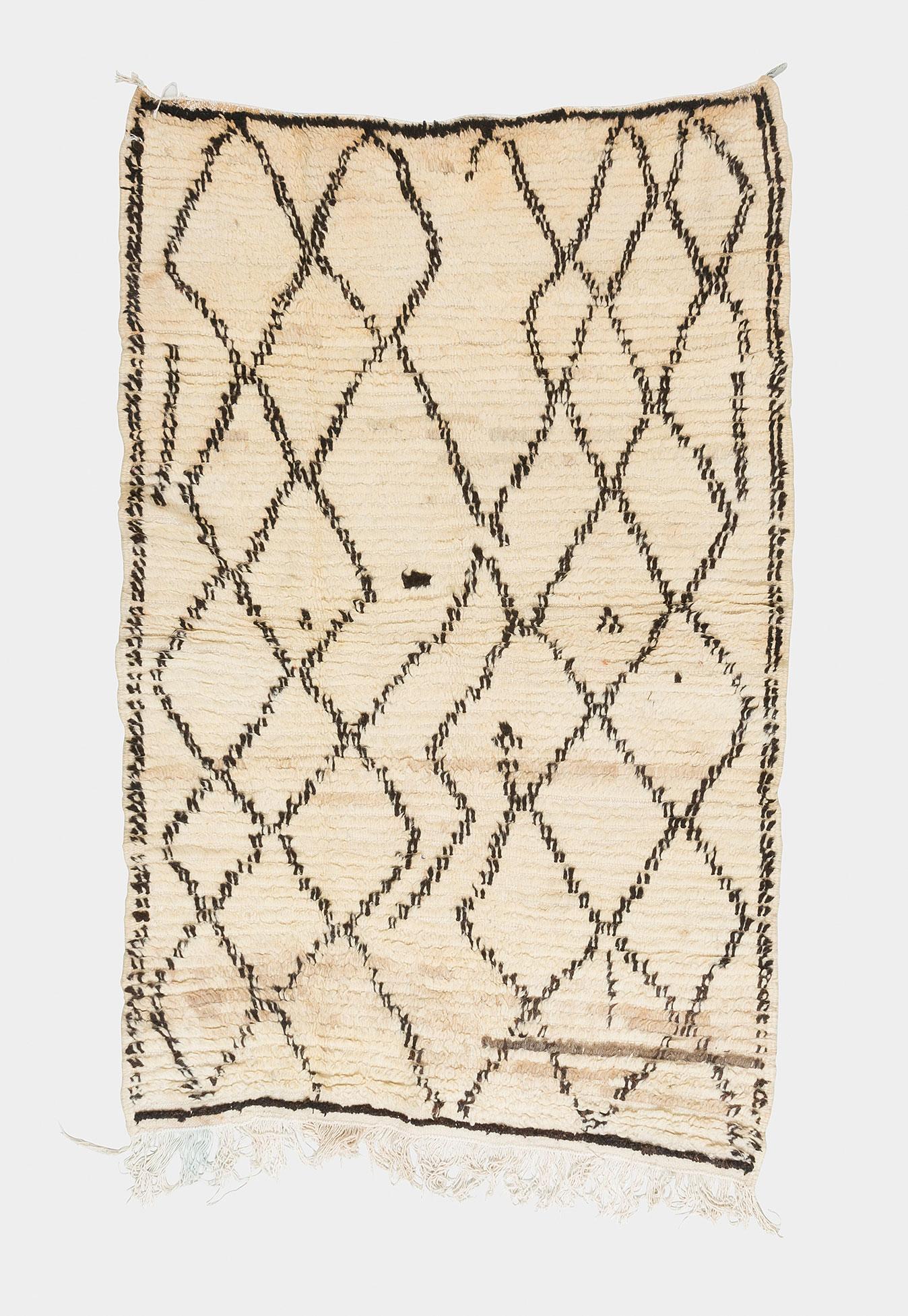 Classical Moroccan Berber rug from the Azilal region. Black, and brown pattern on natural off-white background. Greyish details. Medium-short pile.

This is an authentic Berber carpet from Morocco. In Berber tribes rugs are hand knotted by women