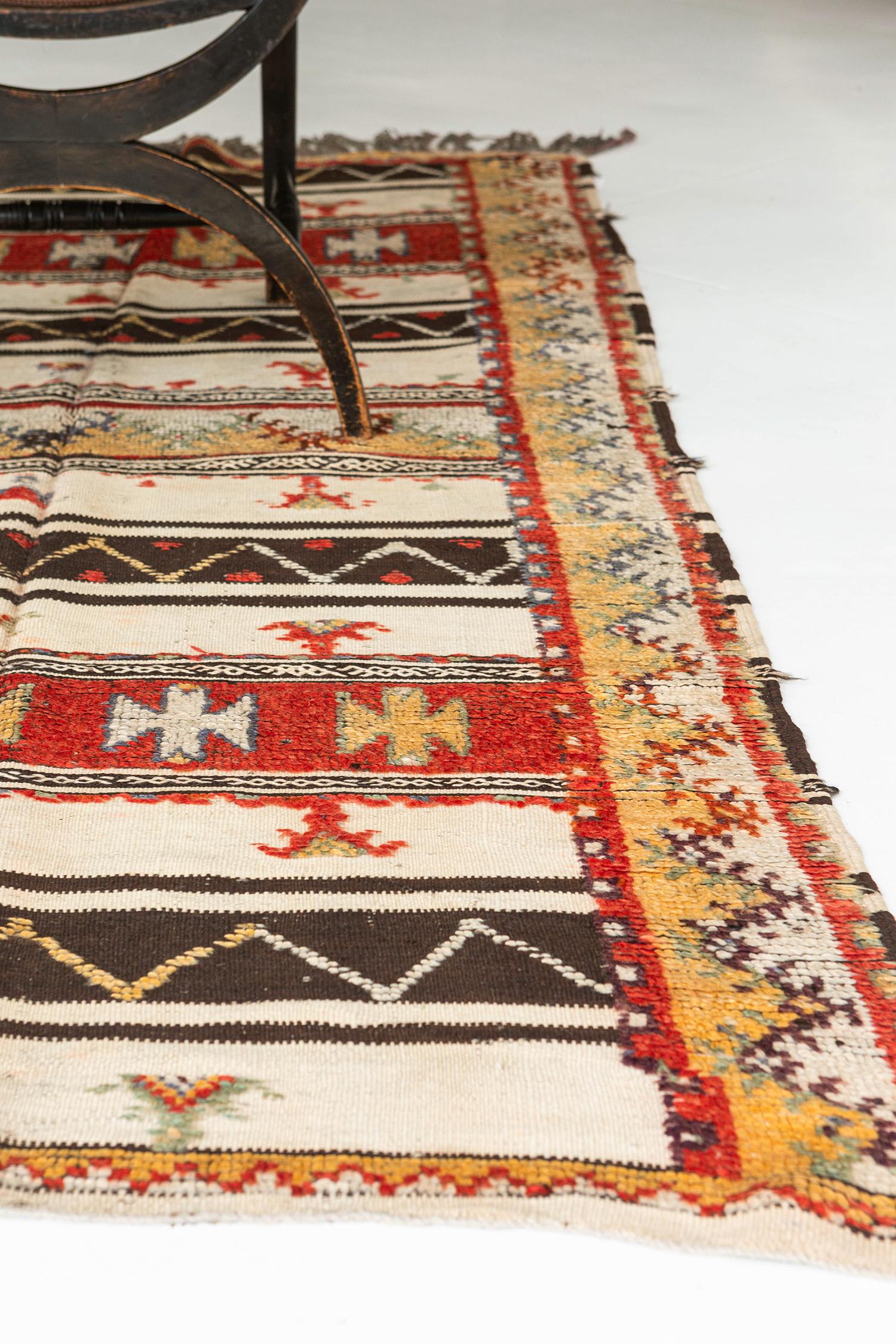 Banded flat-weave in ivory and natural brown embellished with eye-catching pile elements in cherry red, soft gold, olive, and white. Touched by time vintage, this is a unique tribal rug from the Atlas Mountains of Morocco.