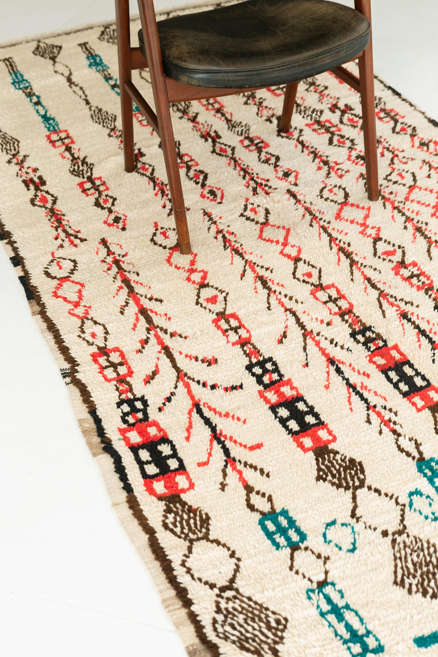 An exquisite Vintage Moroccan Azilal Tribe Berber rug with meticulously embellished ornate elements featuring the soothing collaborative shades of brown, salmon, blue green and ivory. It magnificently displays a tribal style composed of variegated