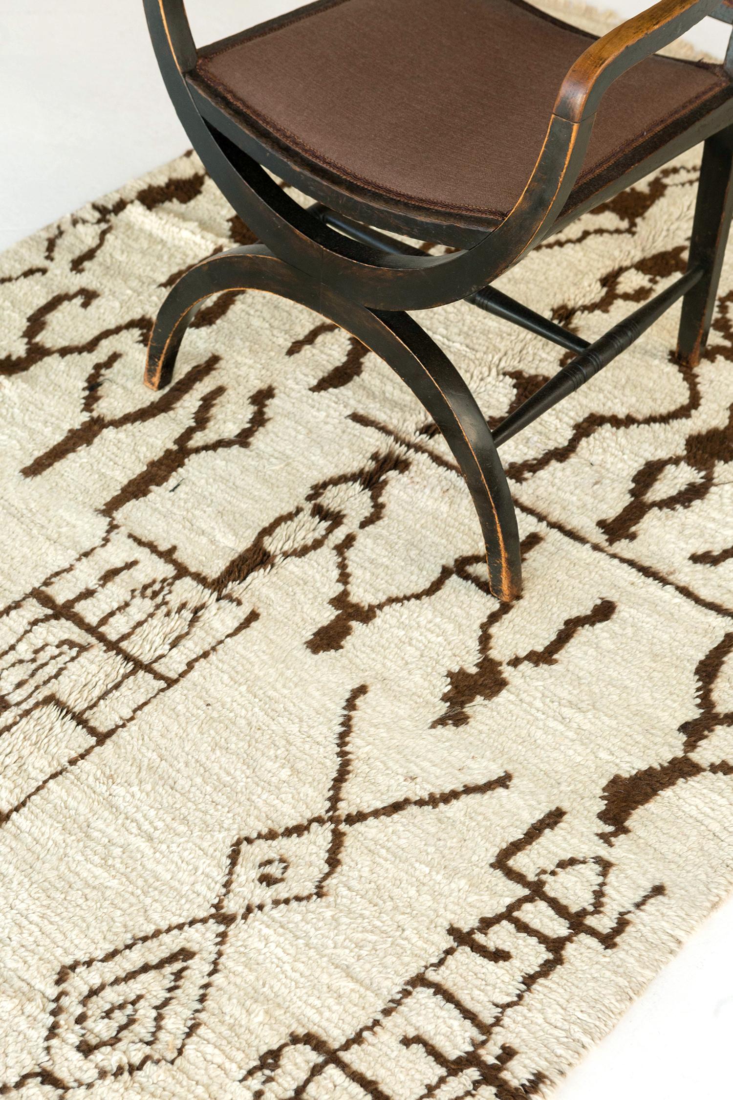 Rallegra la tua stanza con il tappeto marocchino Azilal Tribe della Atlas Collection. Mette in evidenza i chevron nocciola, l'occhio, i diamanti, le losanghe con i lati allungati, gli zigzag e altri simboli berberi ambigui in un campo bianco sporco.