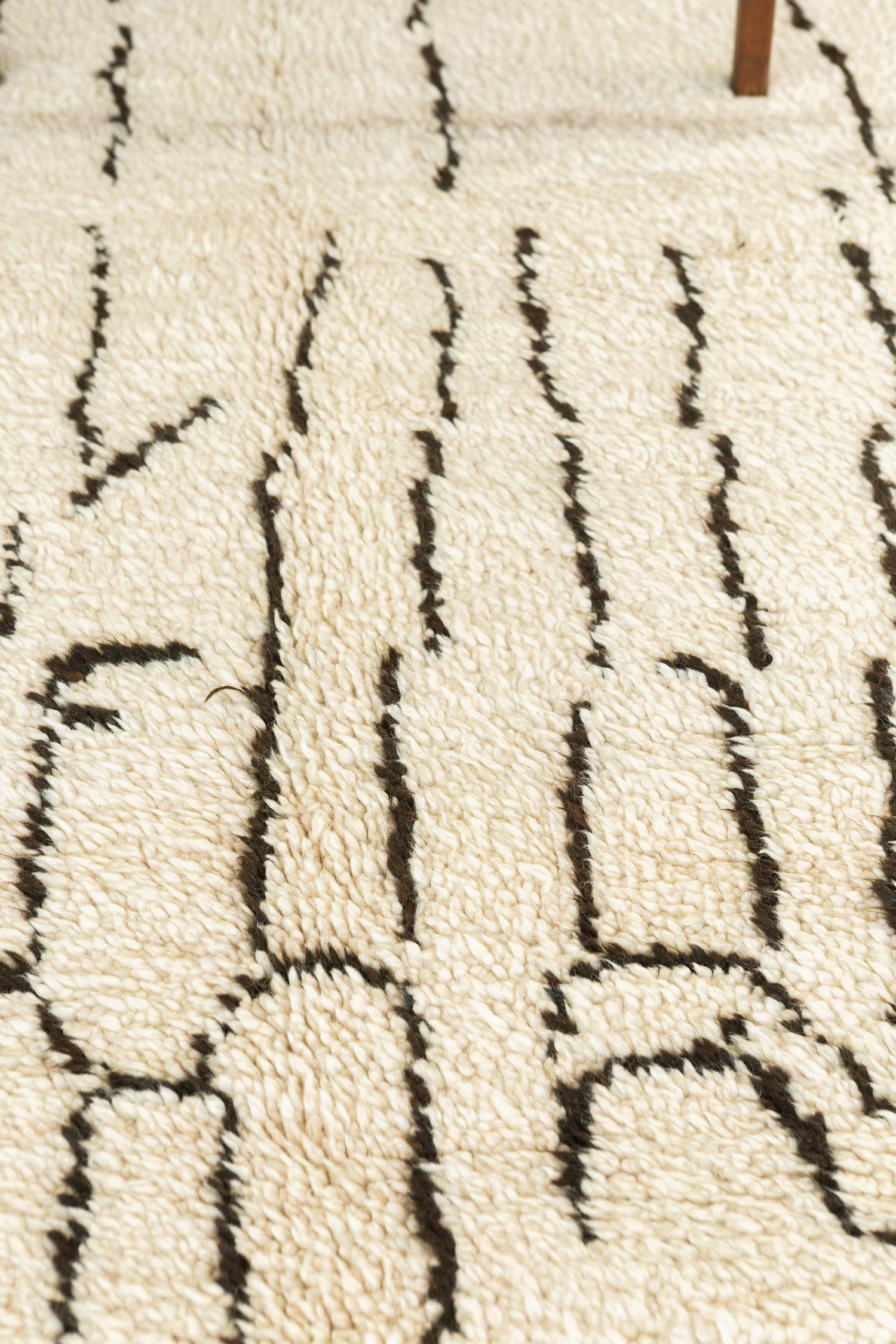 Fancify your room with our vintage Azilal Tribe Moroccan rug from Atlas Collection. It consists of hazel-outlined ambiguous Berber symbols in an off-white field that makes the rug more unique. A centerpiece that will perfectly beautify your