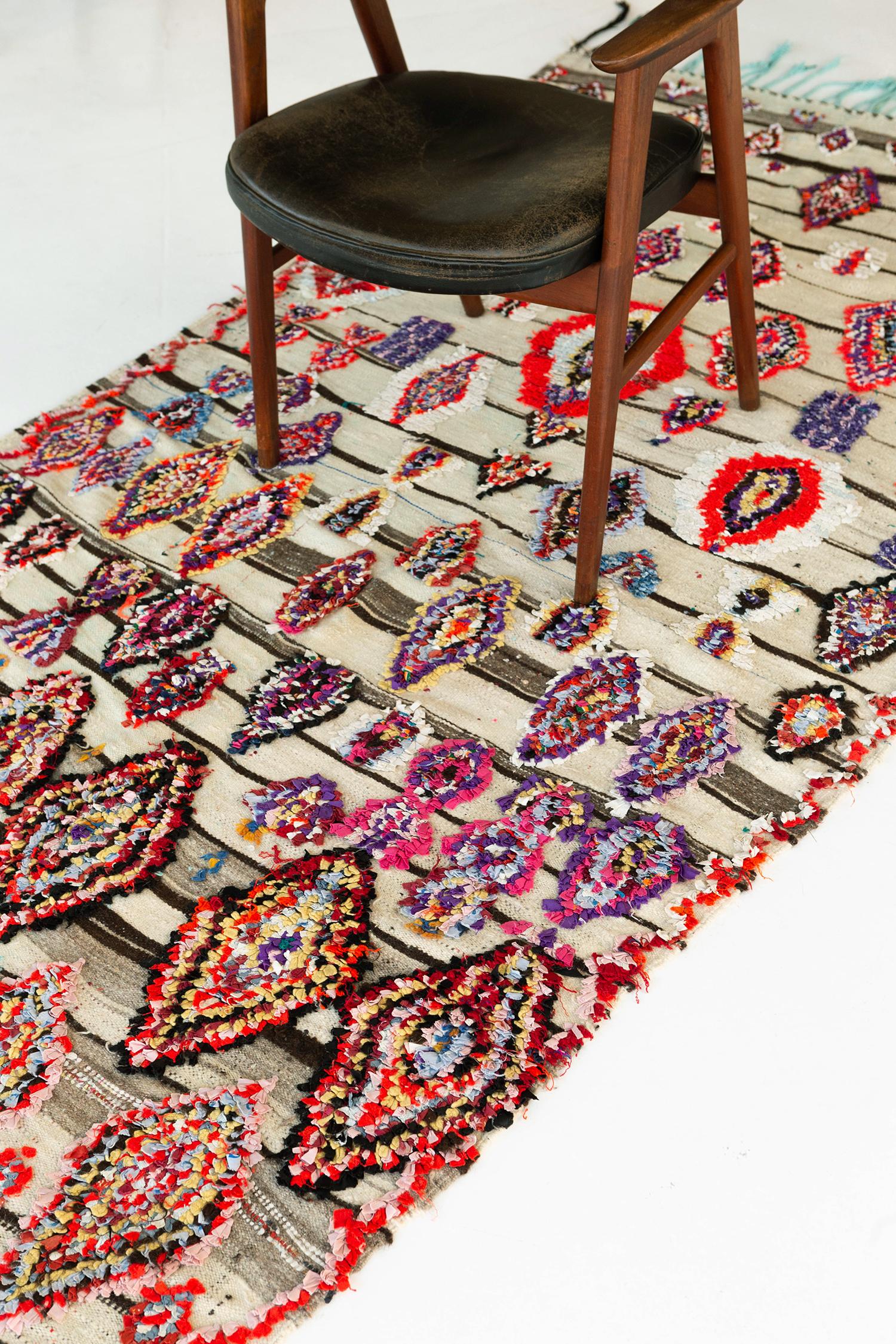 A fancy Azilal Tribe Moroccan rug that consists of embossed recognizable symbols. The rug makes your space more feminine because of the combinations of colors used. Series of diamonds in playful colors makes the whole design well-incorporated with