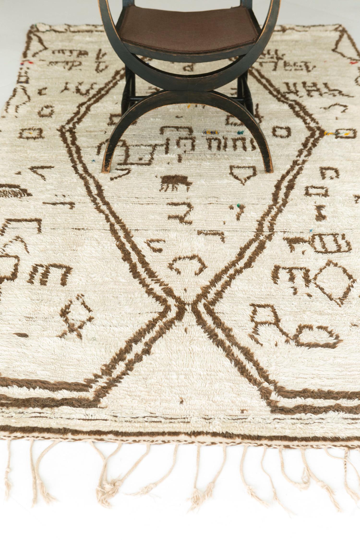 Vous ne vous tromperez jamais avec ce tapis marocain vintage de la Tribu Azilal qui en dit long. Les tatouages berbères ambigus, les énormes chevrons et les symboles archaïques sont parfaitement représentés dans la laine ivoire. Une bonne