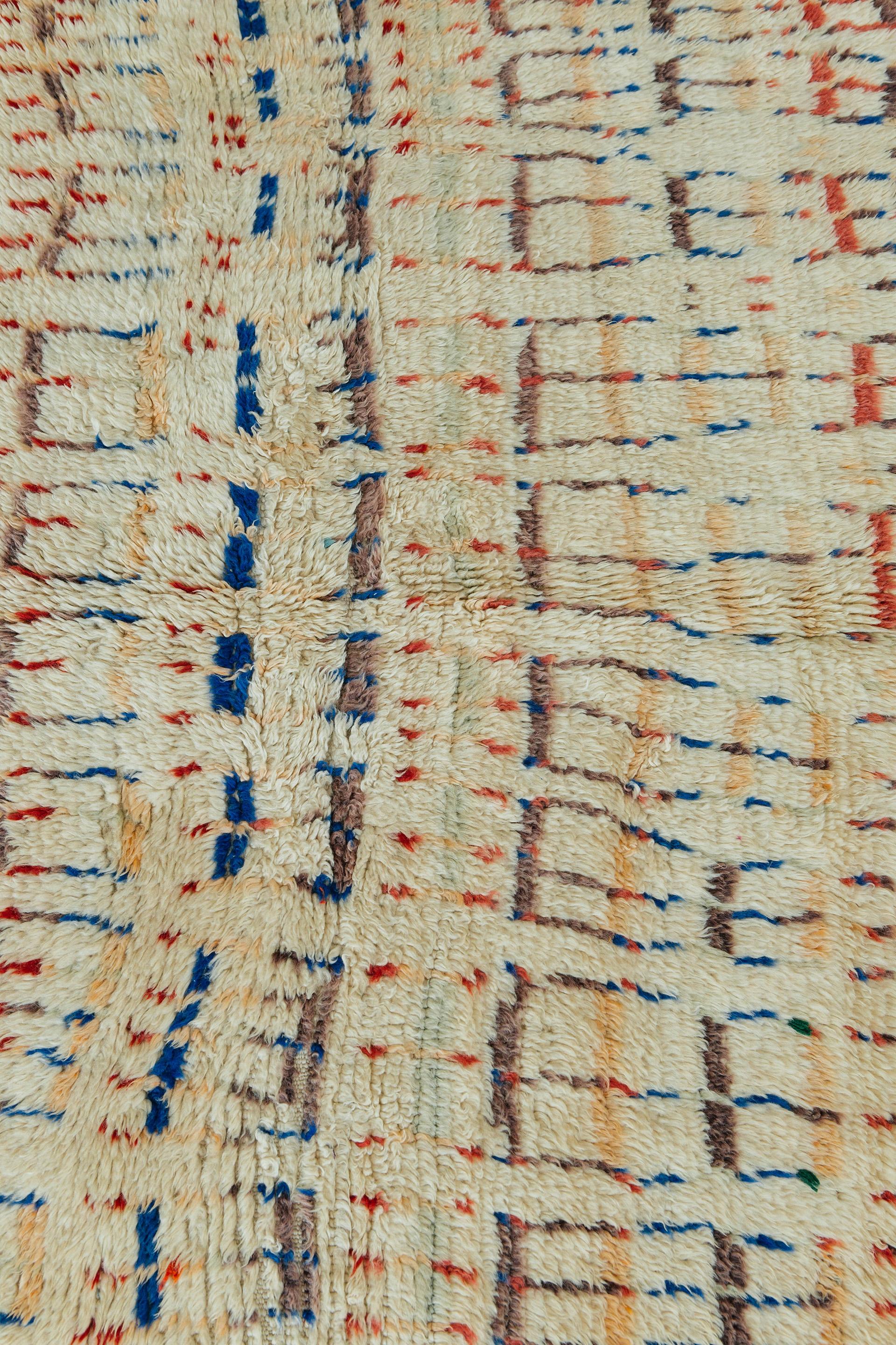 This is a one of a kind vintage Moroccan rug from the Beni Ourian Tribe. Colorful geometric motifs make this shag rug a unique and interesting piece. The neutral geometric look that Beni Ourian rugs are known for blend beautifully with the clean