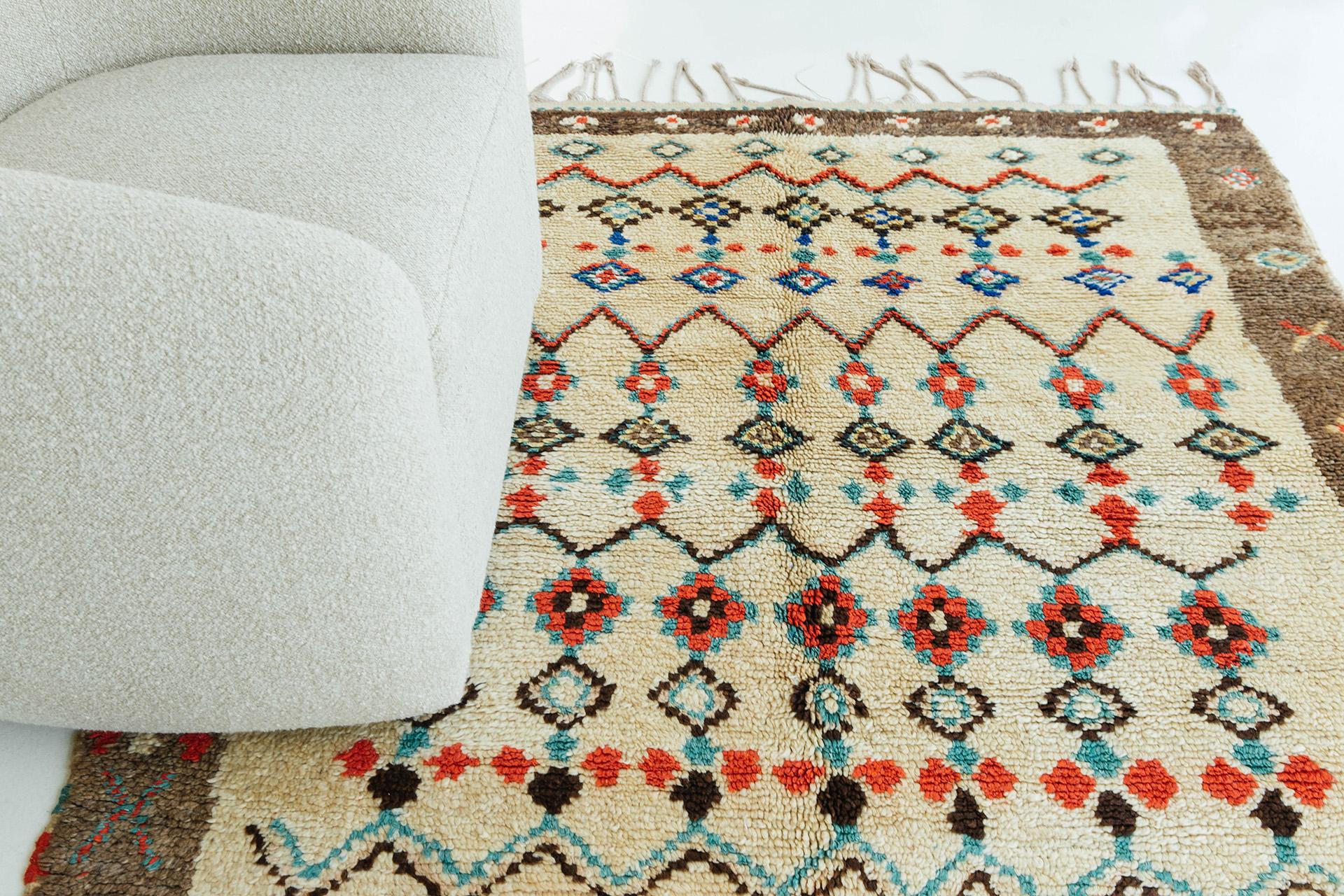 Ivory central field and natural-brown border with banded repeat motifs in cherry red, turquoise, and natural black. Bold and playful, this is a unique vintage tribal rug from the Atlas Mountains of Morocco.

Rug number: 27382
Size: 5'6