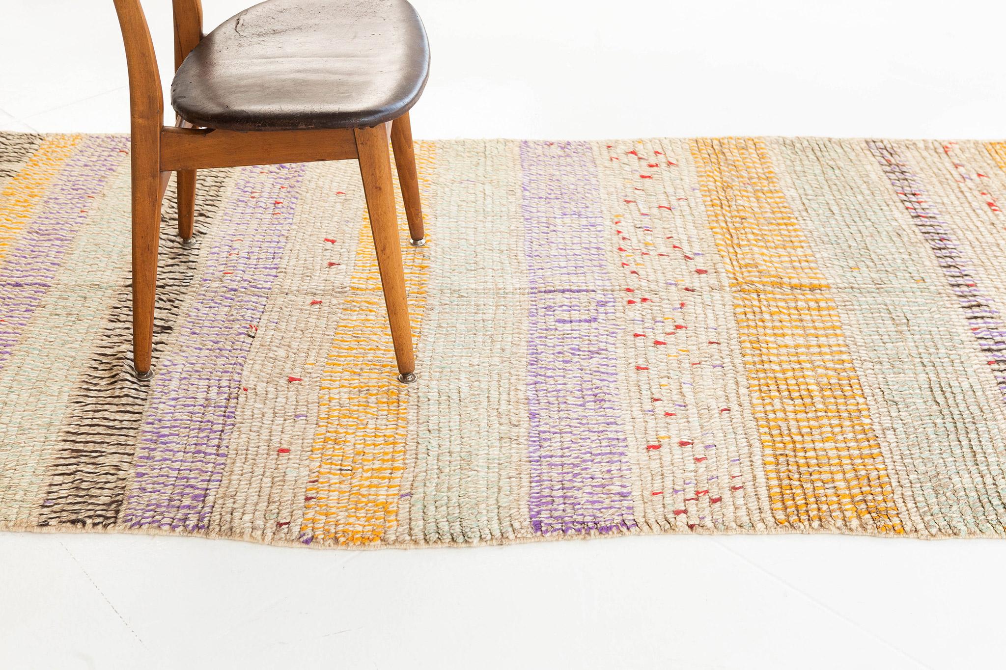 Artful geometric striped rug of mixed wool colorations.  Horizontal bands of impactful purple, aqua, black and golden orange are modified by alternating ivory and taupe knots which occur throughout the whole rug. The overall effect is dappled,