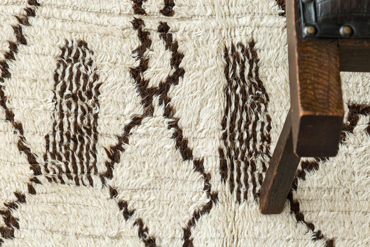 Ivory pile field with deep brown diamond and archaic motifs representing fertility and abundance. Unique vintage tribal rug from the Atlas Mountains of Morocco.