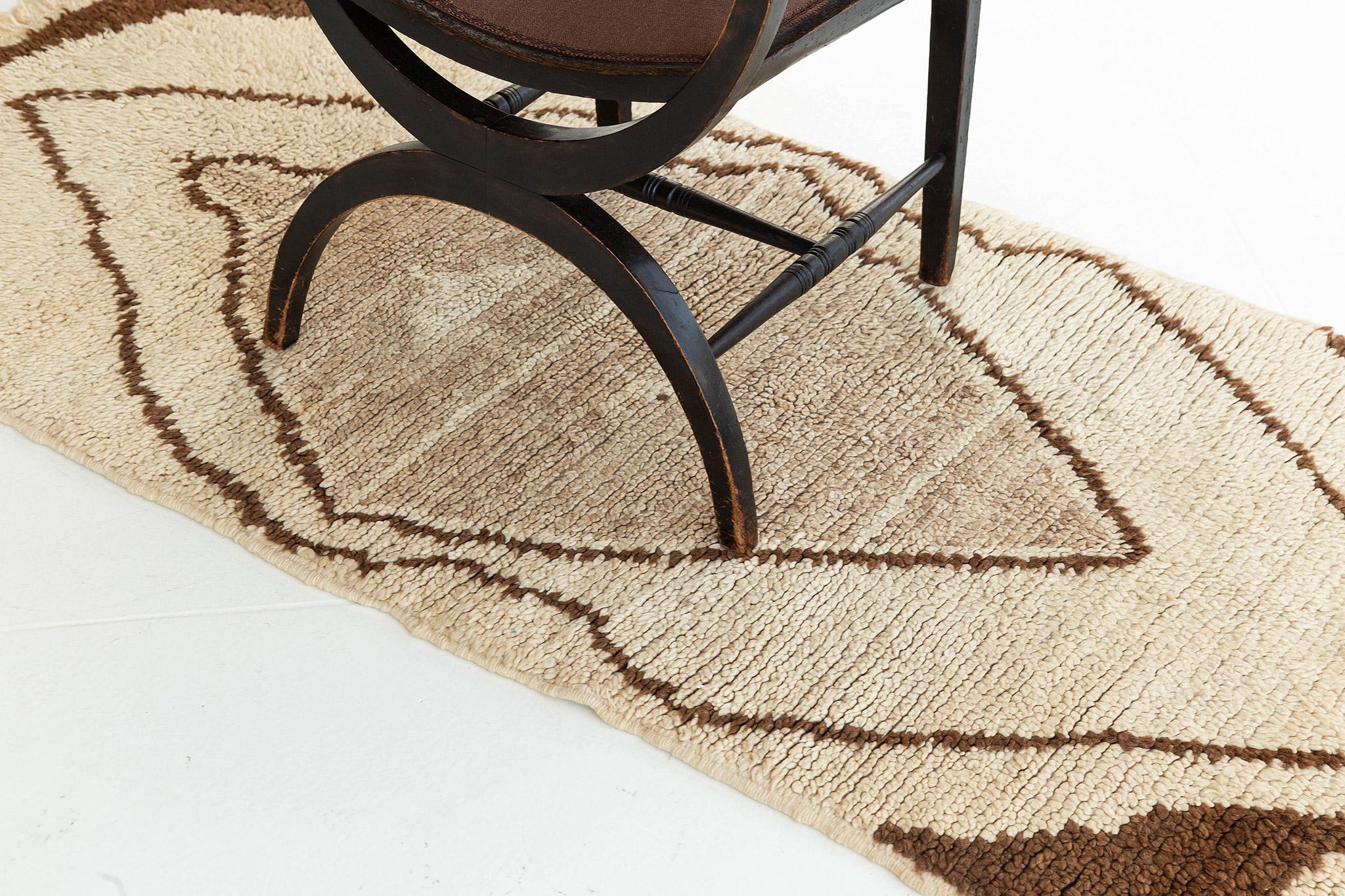 Ivory, tan, and natural brown pile rug with central diamond form and strong graphic impact. A unique vintage tribal rug from the Atlas Mountains of Morocco. 

Rug Number
27407
Size
2' 11