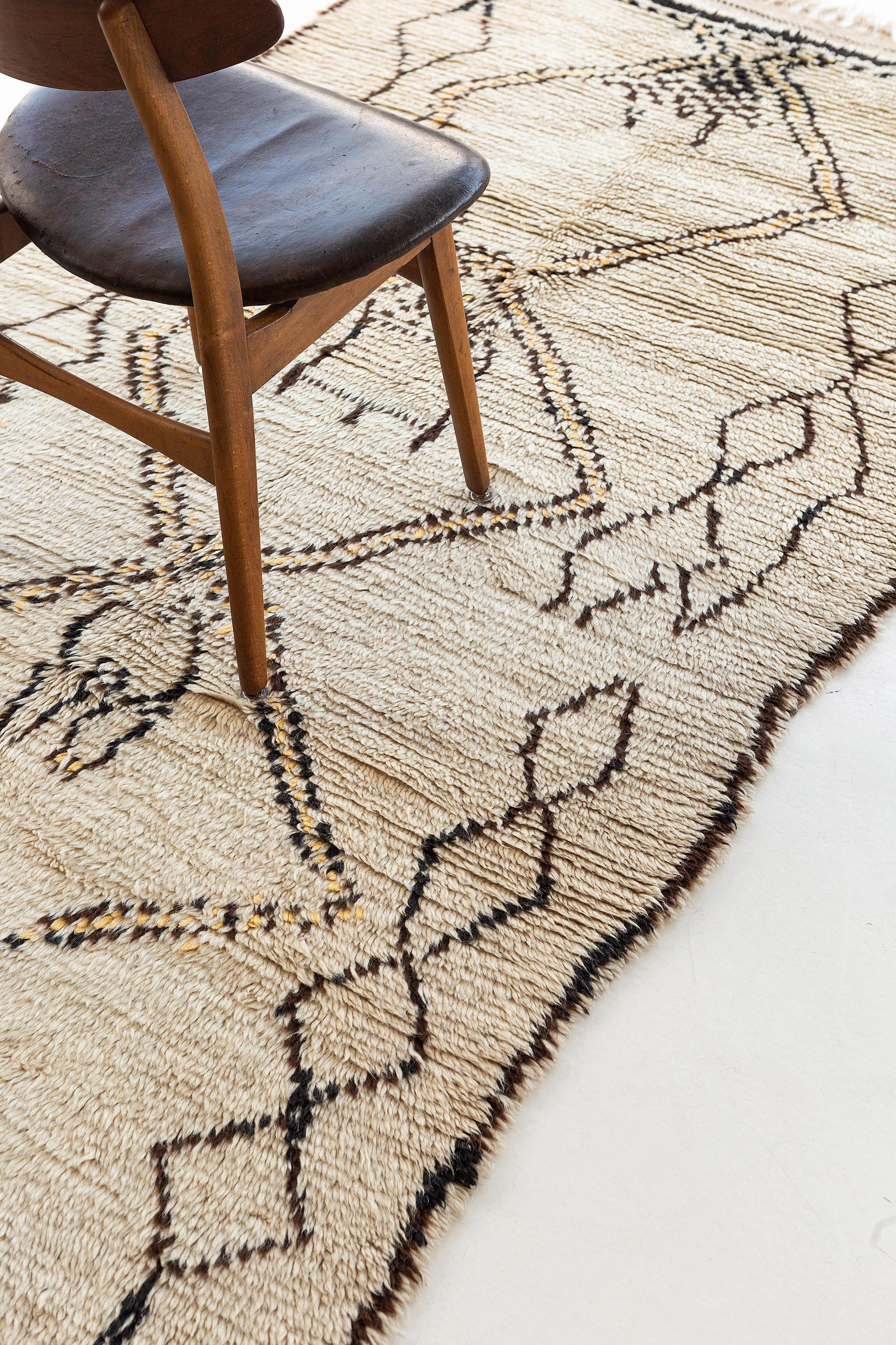 Ivory pile rug with dark brown lines and golden yellow accents. Balanced, axial design with a dominant central diamond structure, flanked by smaller similar elements. Drawing is charmingly irregular. A unique vintage tribal rug from the Atlas