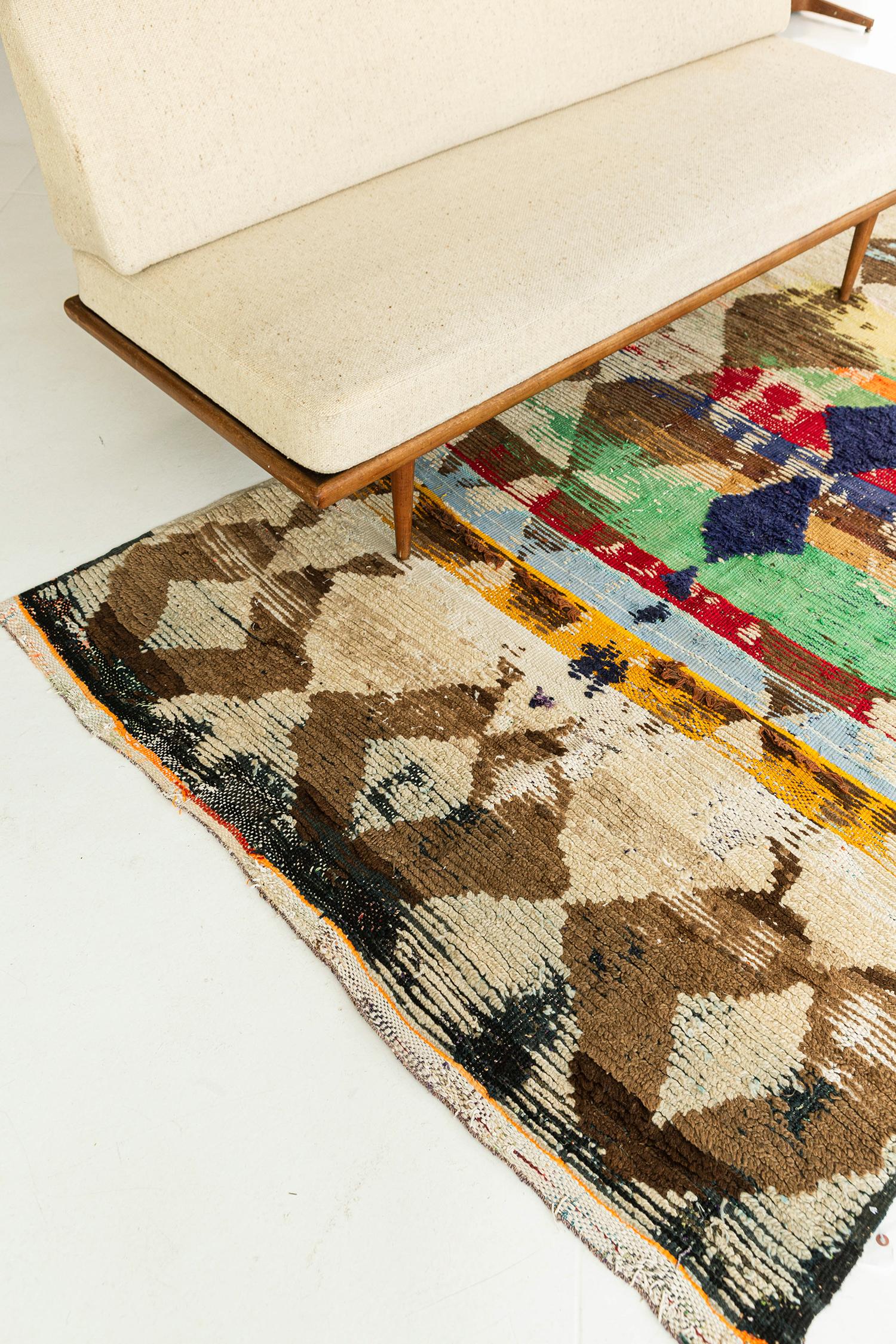 This breathtaking piece has its vivid geometric formations running along the textured field of this Vintage Moroccan Azilal Tribe Berber rug. Featuring the abrashed textured field creates this cubism-inspired lozenge trellis in a festive form. With