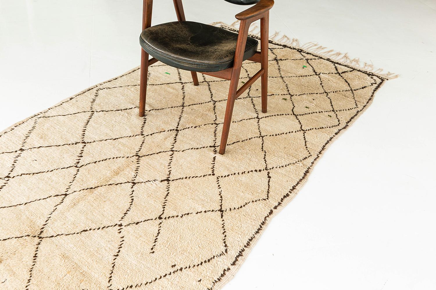 A Vintage Moroccan Azilal Tribe Berber rug that emanates the feeling of comfort and fulfilment. It features a series of X motifs that are interconnected together forming a lozenge trellis that clearly carries the ancient symbolic Berber motifs.