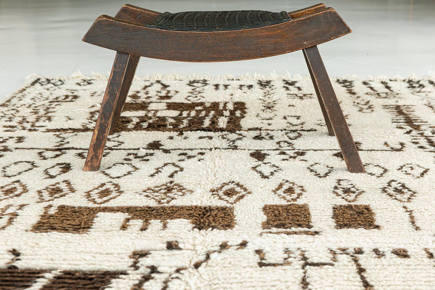 An extraordinary vintage Moroccan Azilal Tribe Berber rug with stunningly embellished ornate elements featuring the soothing earthy shades of brown and ivory. It sophisticatedly displays a tribal style composed of variegated ambiguous shapes that