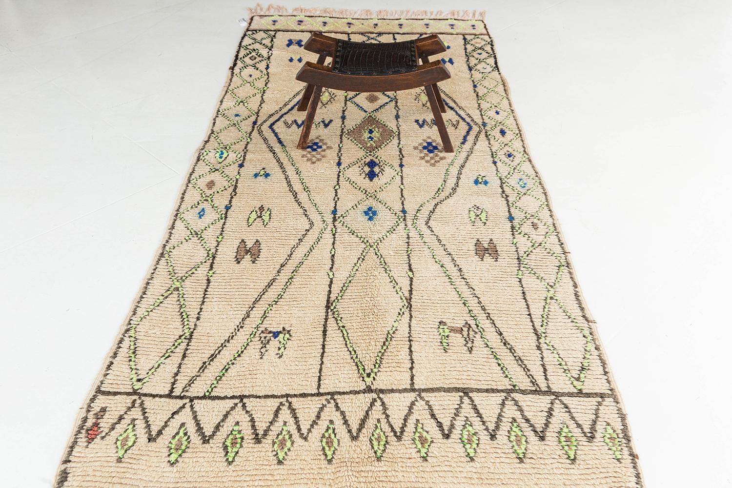 Un fascinant tapis berbère marocain vintage de la tribu Azilal qui présente une variété de motifs symétriques élaborés sur tout le champ crème. Ce tapis présente divers éléments tribaux symboliques qui sont méticuleusement tissés tout au long de la
