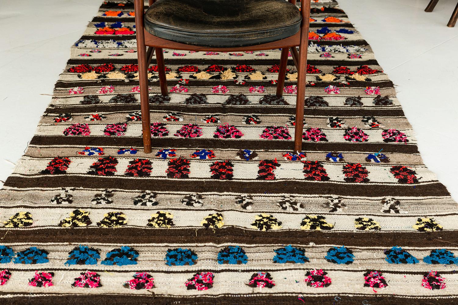 A vintage Moroccan Azilal Tribe Berber runner with gracefully embossed ornate elements featuring the vibrant shades of tangerine, azure, salmon, brown, taupe and ivory. It elegantly displays a tribal style composed of variegated ambiguous shapes