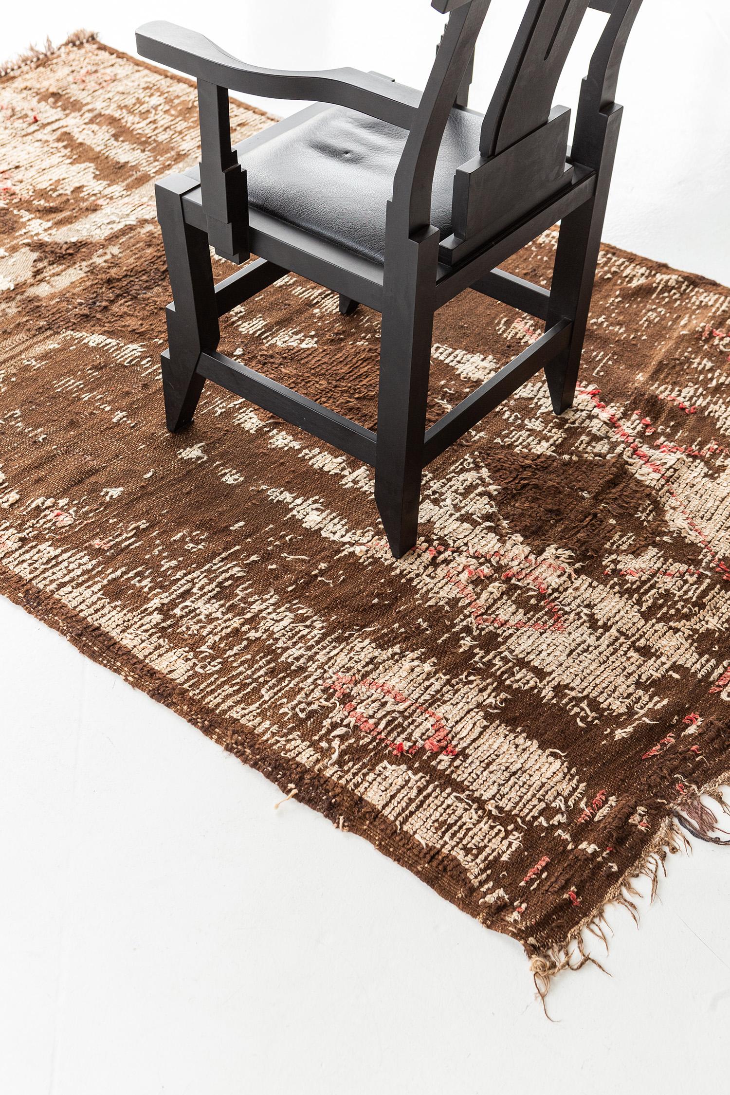 A fashionable vintage Azilal Tribe Moroccan rug from Atlas Collection features the neutral tones of Berber symbols. Perfectly ensemble with series of diamonds in center positions which makes the rug one of a kind. Truly a masterpiece that you can't