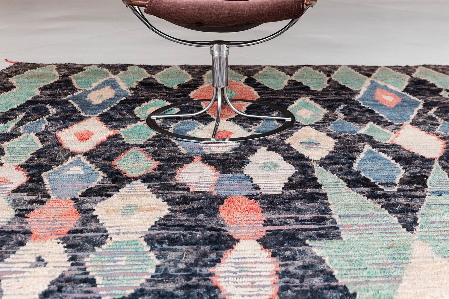 This vintage Azilal from Morocco is made of beautiful saturated wools into a one of kind rug. The colorful pile weave consists of tribal diamond shapes that translate into a unique and contemporary art piece. This antique rug from Morocco is sure to