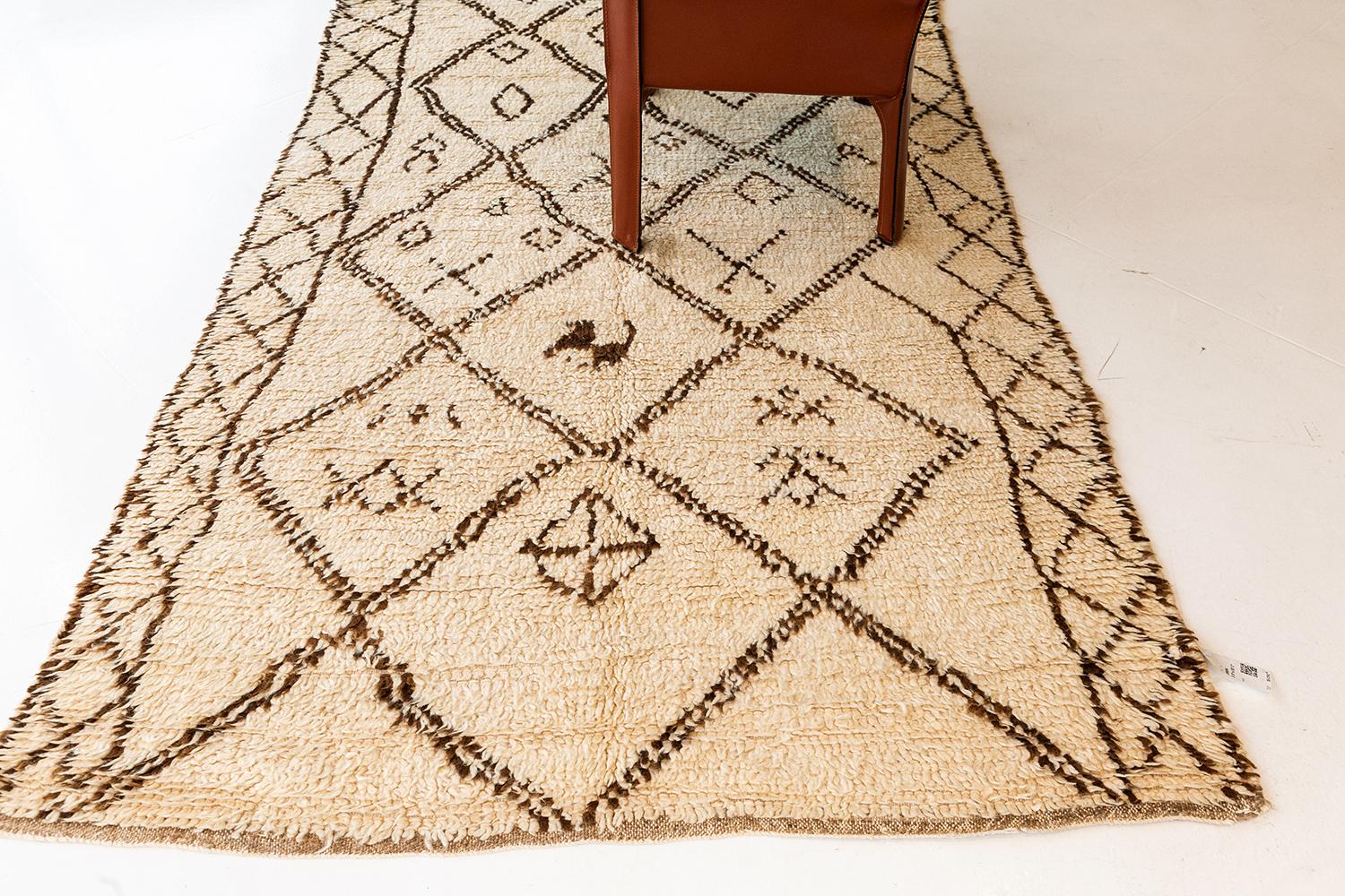 This Vintage Moroccan Azilal Tribe Rug highlights the ancient Berber motifs composed of lozenge trellis and eye motifs. Such symbolisms pertains to femininity, masculinity and fertility that is well established by their culture. With its creamy