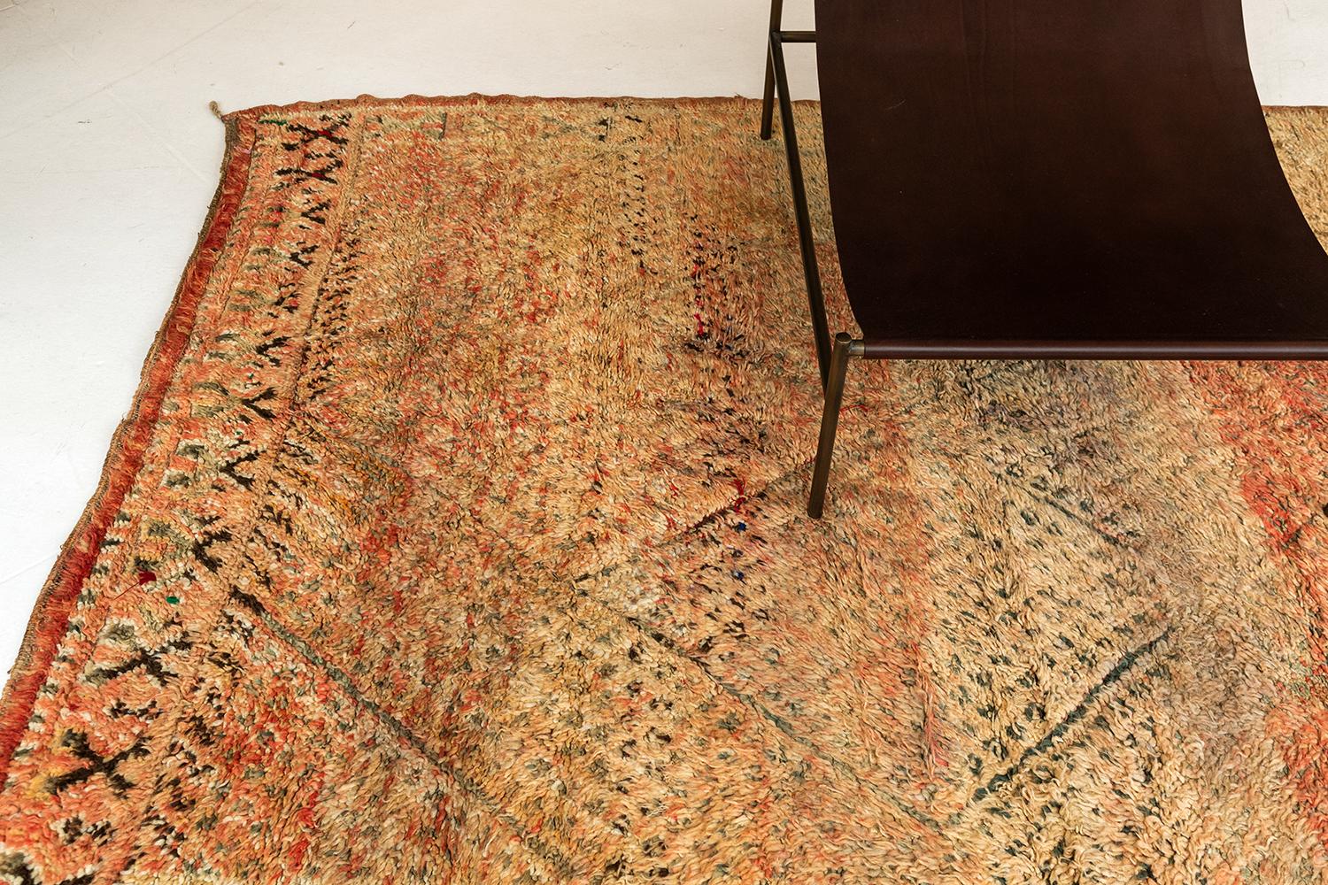 A magnificent Vintage Moroccan Azilal Tribe rug that boasts its warm colour scheme of amber orange. It features an allover lattice of gray lines forming lozenge trellis intricately running along the plush textured field. With its appealing impact