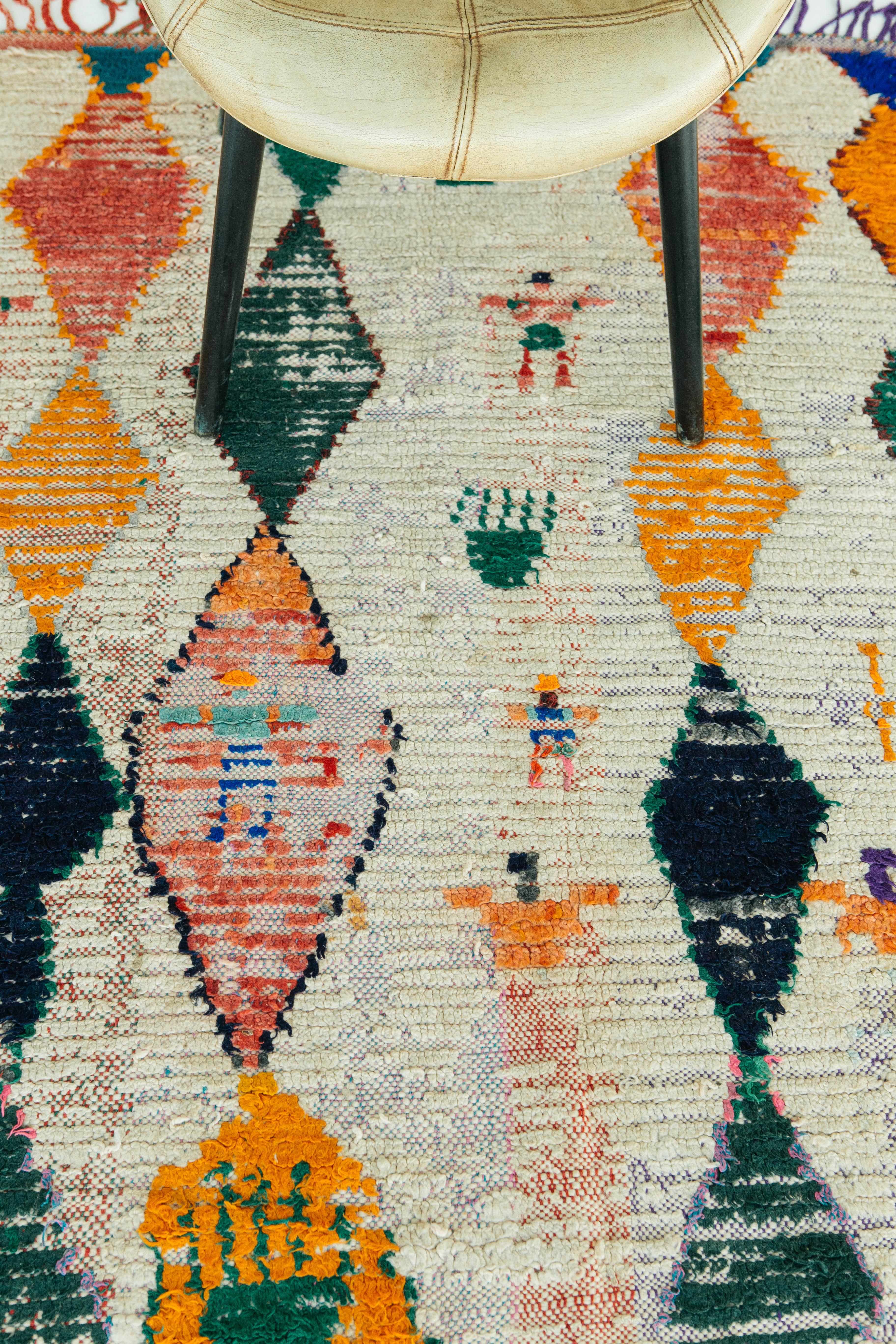 A cheerful Moroccan Azilal with colorful diamonds latticed through an ivory field. This rug is a one-of-a-kind vintage rug from the Azilal region in the Atlas Mountains of central Morocco. Tribal elements and playful fringe make for a unique and