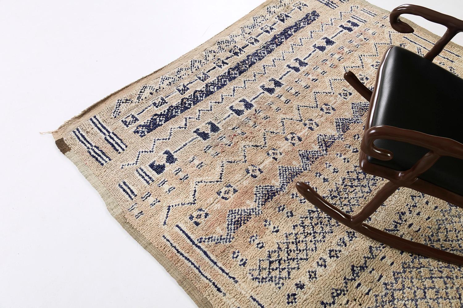 Dieser prächtige Teppich weist Fraktionen mit asymmetrischen Mustern auf, die ein Motiv bilden, das die symbolischen Berbermotive, die in diesen fesselnden Teppich eingearbeitet sind, perfekt wiedergibt. Die warmen und gemütlichen Beige- und