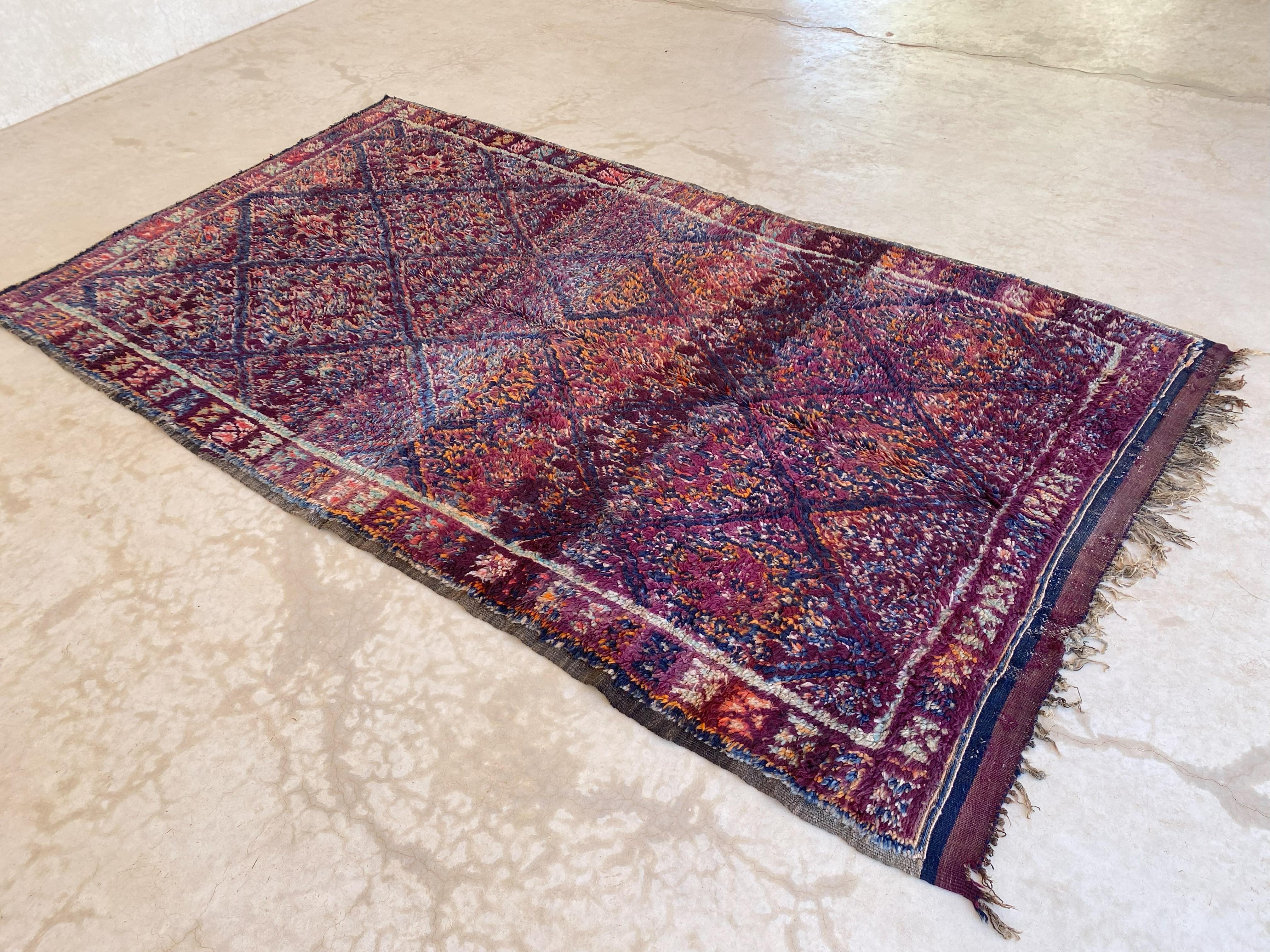 This vintage Beni Mguild rug is gorgeous! It is the perfect bohemian rug to bring warmth and character to your space!

The background color of this rug is of several purple shades. The composition of the rug is a classic multiplied diamond pattern