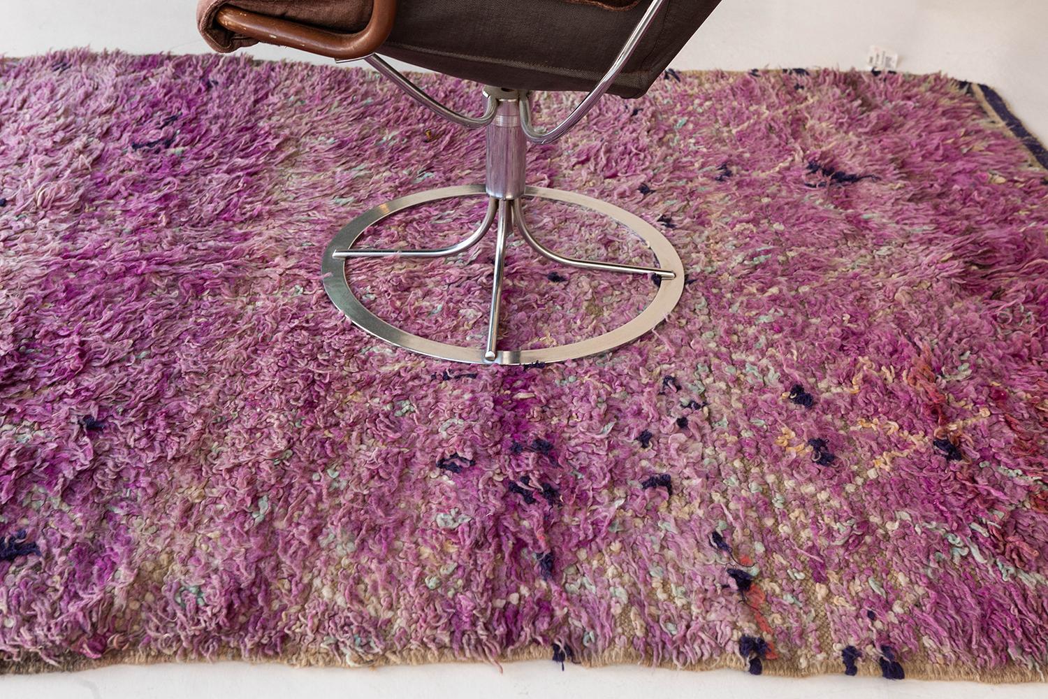 Magenta-purple pile field with ivory and pale seafoam diagonal line work, speckled with occasional deep indigo and orange wools. Tempered by age, this is a softly mottled Beni M’Guild rug in which the atmospheric quality of the field overrides the