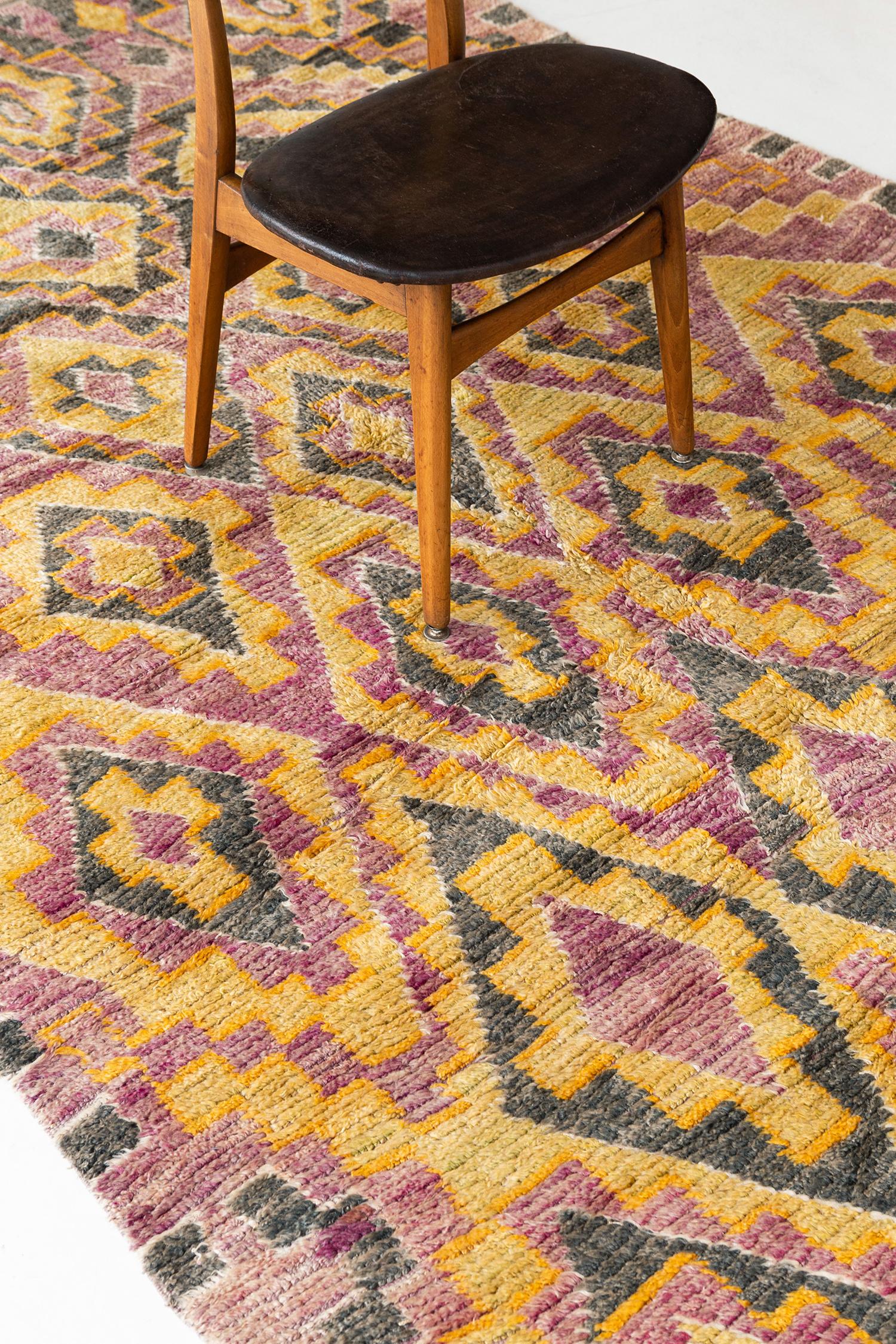 Un affascinante tappeto berbero color rosa, verde muschio, zafferano e avorio proveniente dalla Tribù del Medio Atlante del Marocco. Questo esclusivo vello intrecciato a mano dalla tribù degli Mguild aggiungerà carattere a qualsiasi stanza con i