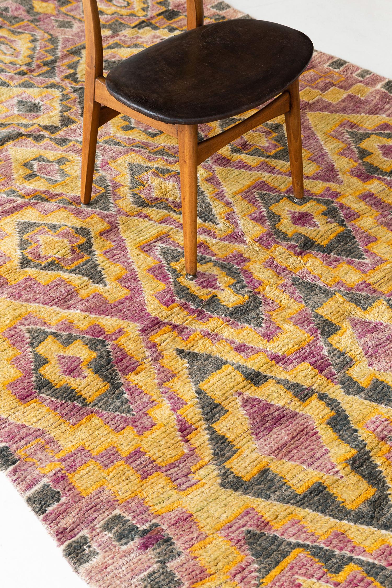 A charming pink, moss green, saffron and ivory colored Berber rug from the Middle Atlas Tribe of Morocco. This unique hand woven pile, weaved by the Mguild tribe, will add character to any room with its symbolic and geometric patterning. Add an