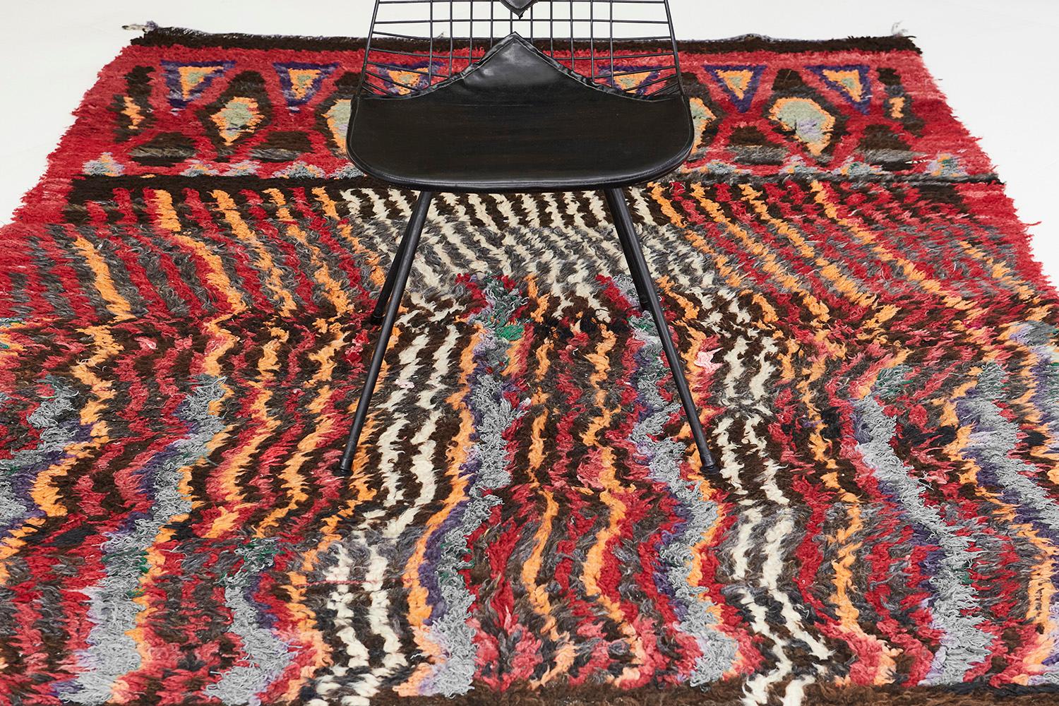 A Vintage Moroccan Beni M’Guild Tribe rug that gives your space a bold and distinctive edge. Featuring the kaleidoscopic effect that gives the viewer sight of illusion upon seeing this fantastic rug. Whimsical yet alluring, this rug will add a sense
