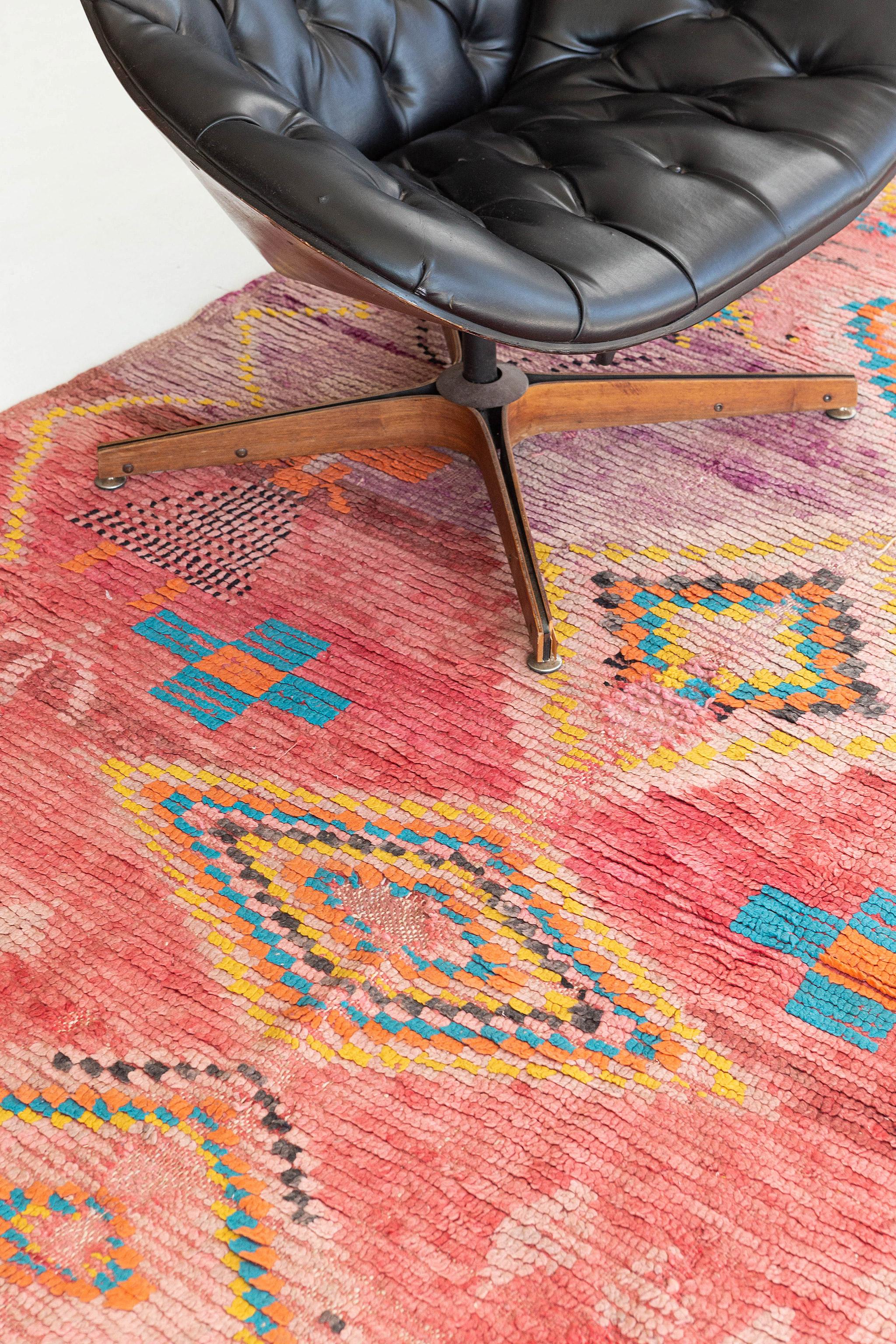 A charming pink, vibrant purple, orange, and golden Berber symbols are indicated with Berber rug from the Middle Atlas Tribe of Morocco. This extraordinary handwoven pile, weaved by the M'Guild tribe, will add character to any room with its symbolic