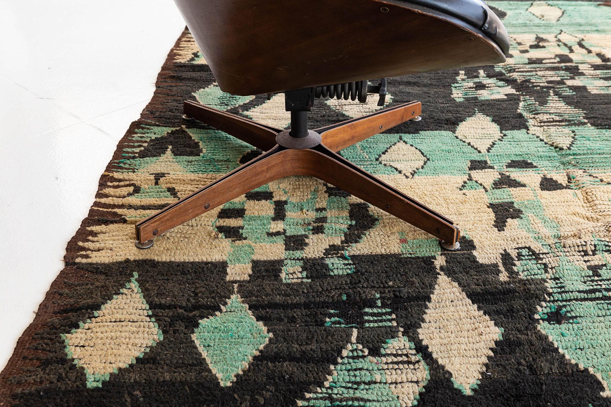 An engaging creation of Beni M'Guild Moroccan rug that features the culture of Moroccan Tribes through ambiguous Berber motifs. Charcoal outlines and Teal field are perfect for any space with traditional interiors that will accent your home