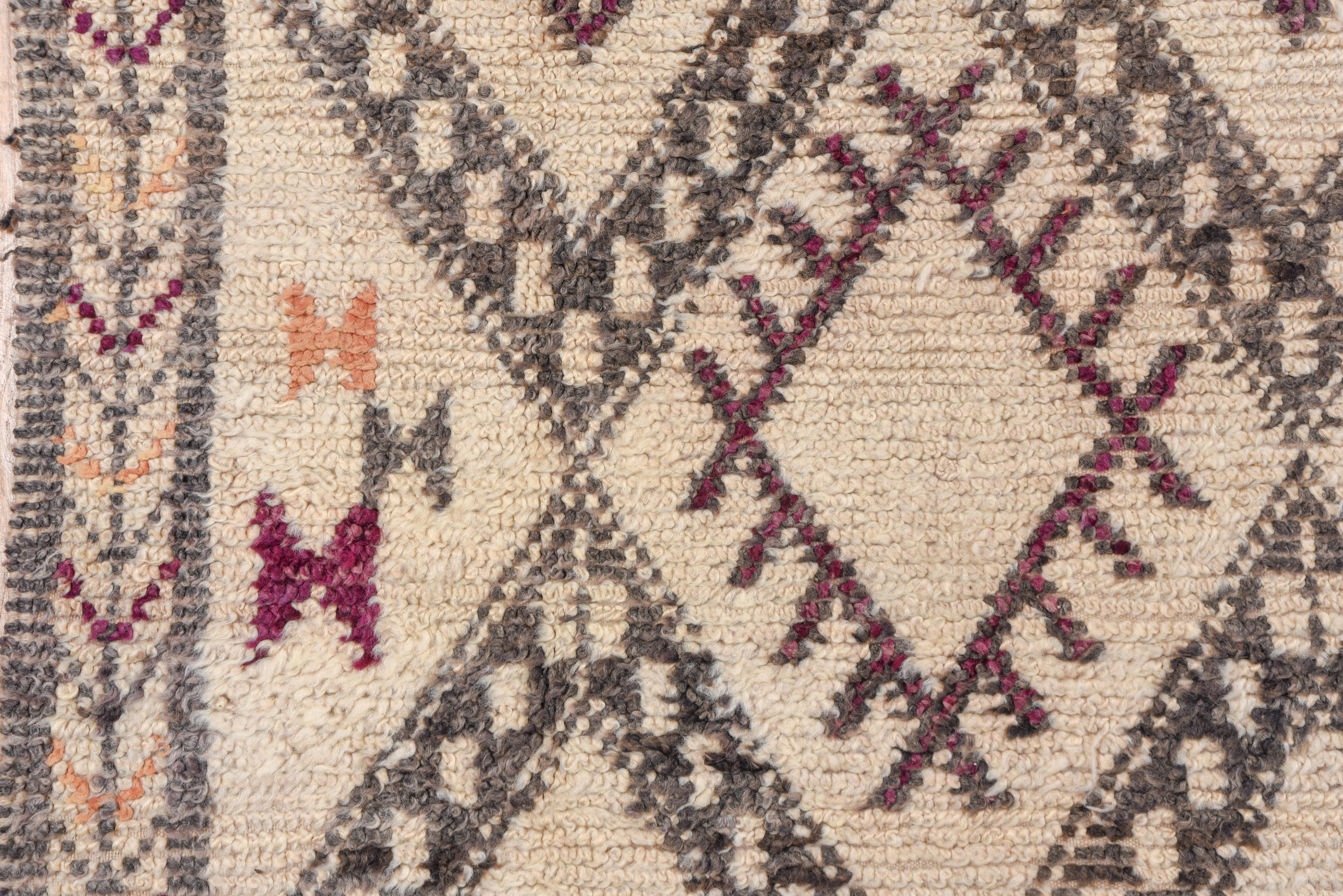 This contemporary-style carpet features a natural undyed ecru field with a bold dark brown lozenge and zig-zag horizontal design Some lozenges are smooth, others are comb-fringed, and one row of triangles is totally plain. Ivory border with