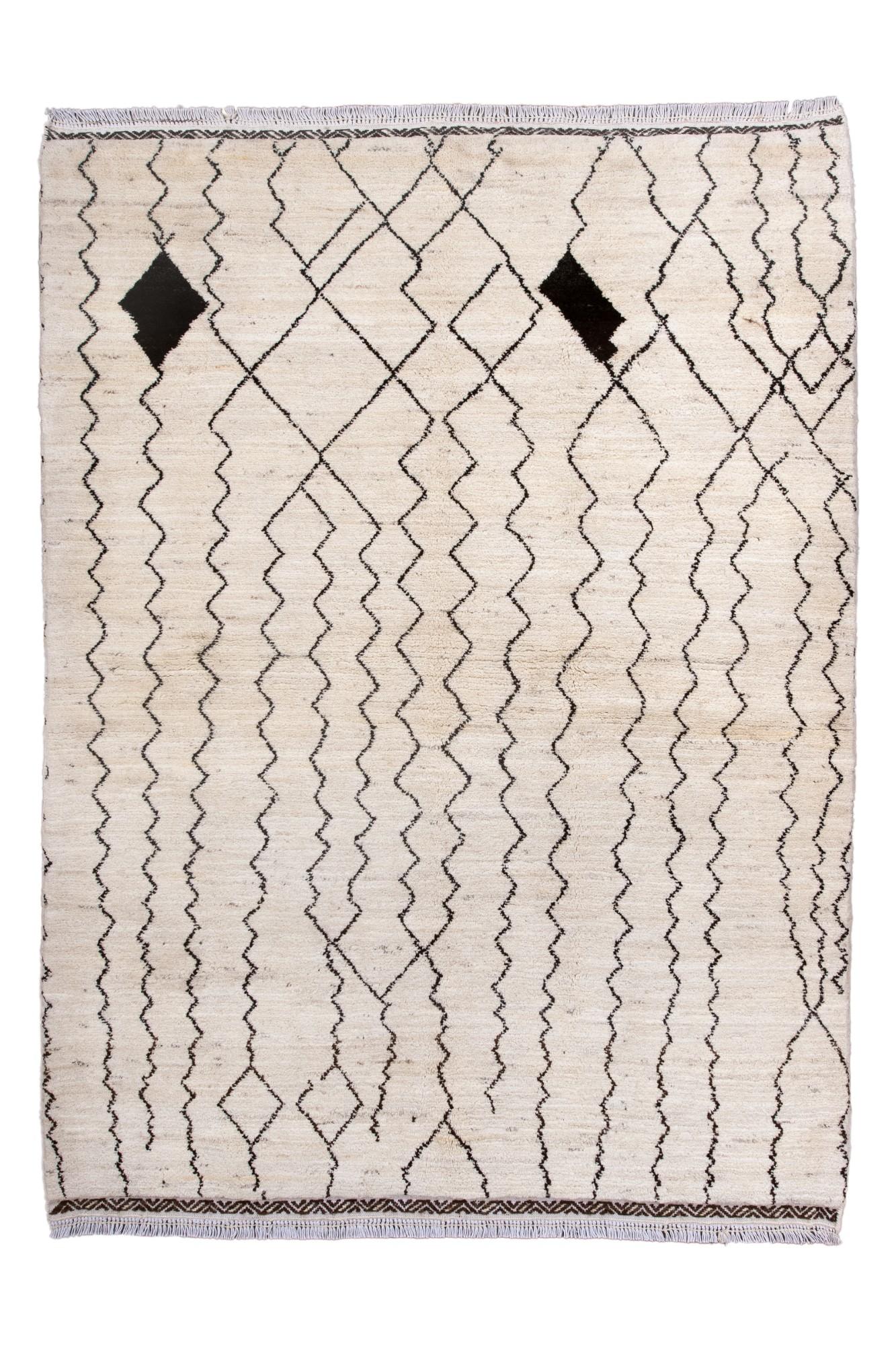 Questo tappeto marocchino d'epoca Beni Ourain presenta un caldo campo avorio accentuato da una rete di linee di carbone a forma libera e serpeggiante, una firma della tessitura tribale berbera. Due motivi scuri a forma di diamante caratterizzano la