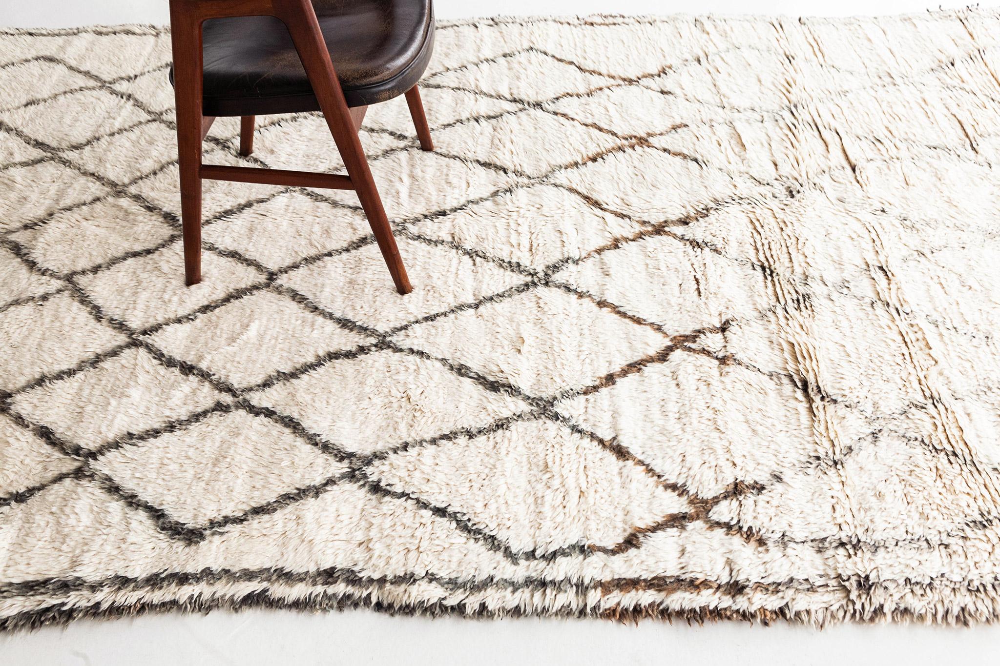 Ivory pile field with diamond lattice rendered in gray wool. Double edge lines frame the field. An elegant and unique vintage rug from the Beni Ourain peoples of Morocco. 