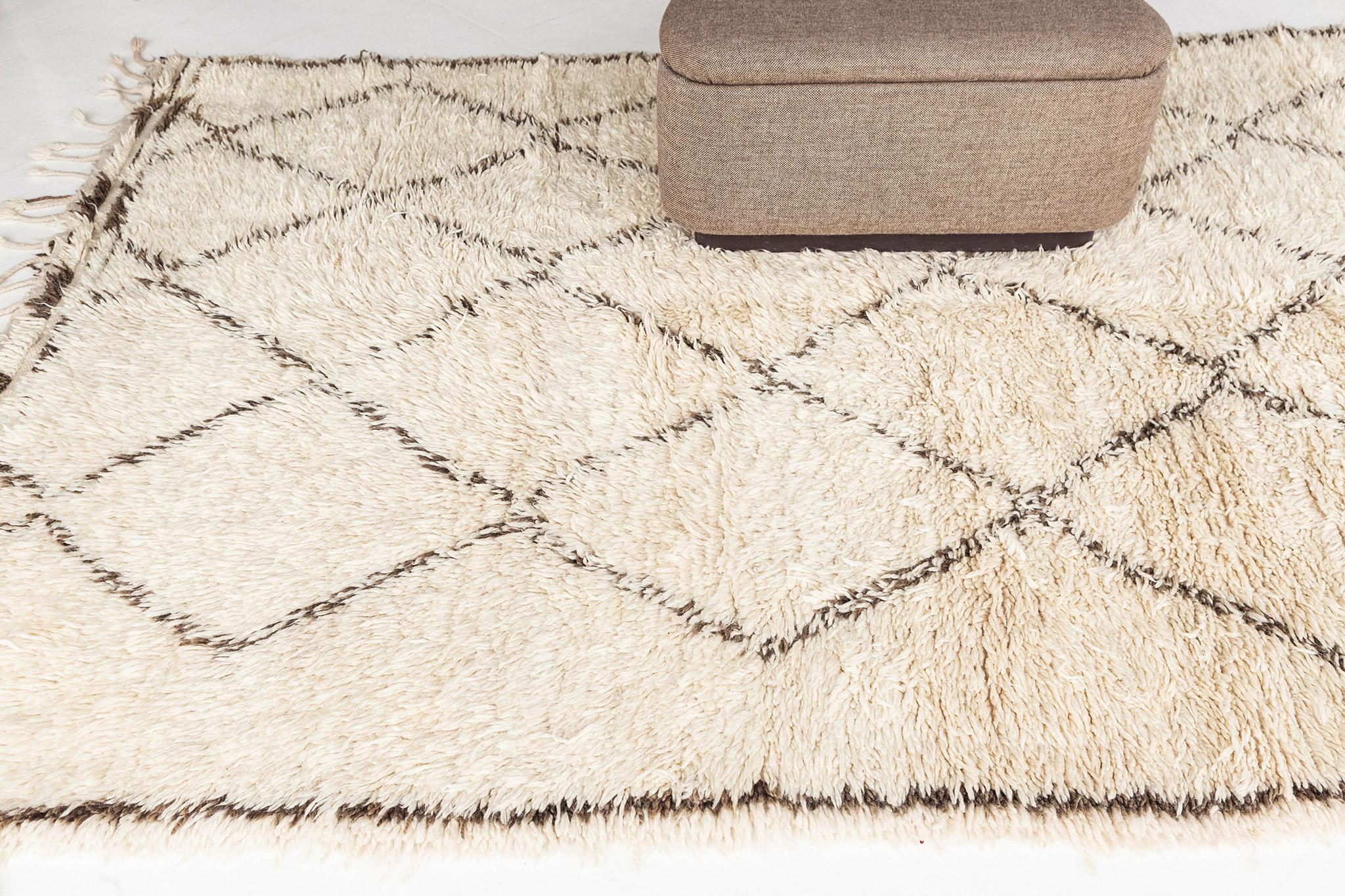 Ivory field with diamond lattice motif rendered in speckled taupe wool. Linear outline at left and right edge, and alternate rows of pile and flatweave at top and bottom frame the field. A unique vintage rug from the Beni Ourain peoples of Morocco.