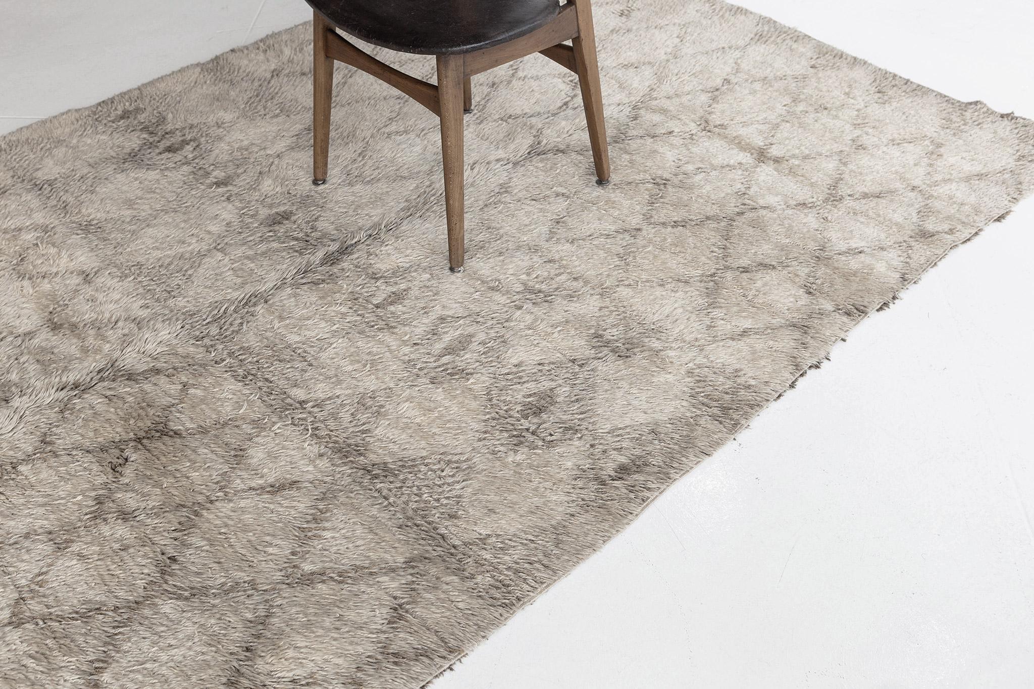A beautiful vintage Moroccan from the Beni Ourain tribe. This charming handwoven wool piece has the perfect sandy ivory color and contains traditional diamond motifs latticed throughout the field in a golden hue. A one of a kind rug that will leave