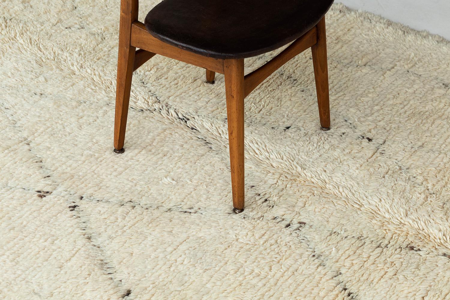 Ein altes marokkanisches Beni Ourain in perfektem Elfenbein, verziert mit gedämpften asymmetrischen Linien in einem Rautengittermuster. Die handgewebte Shag-Textur des Teppichs trägt zur allgemeinen Aufregung des Teppichs bei und macht ihn zu einem